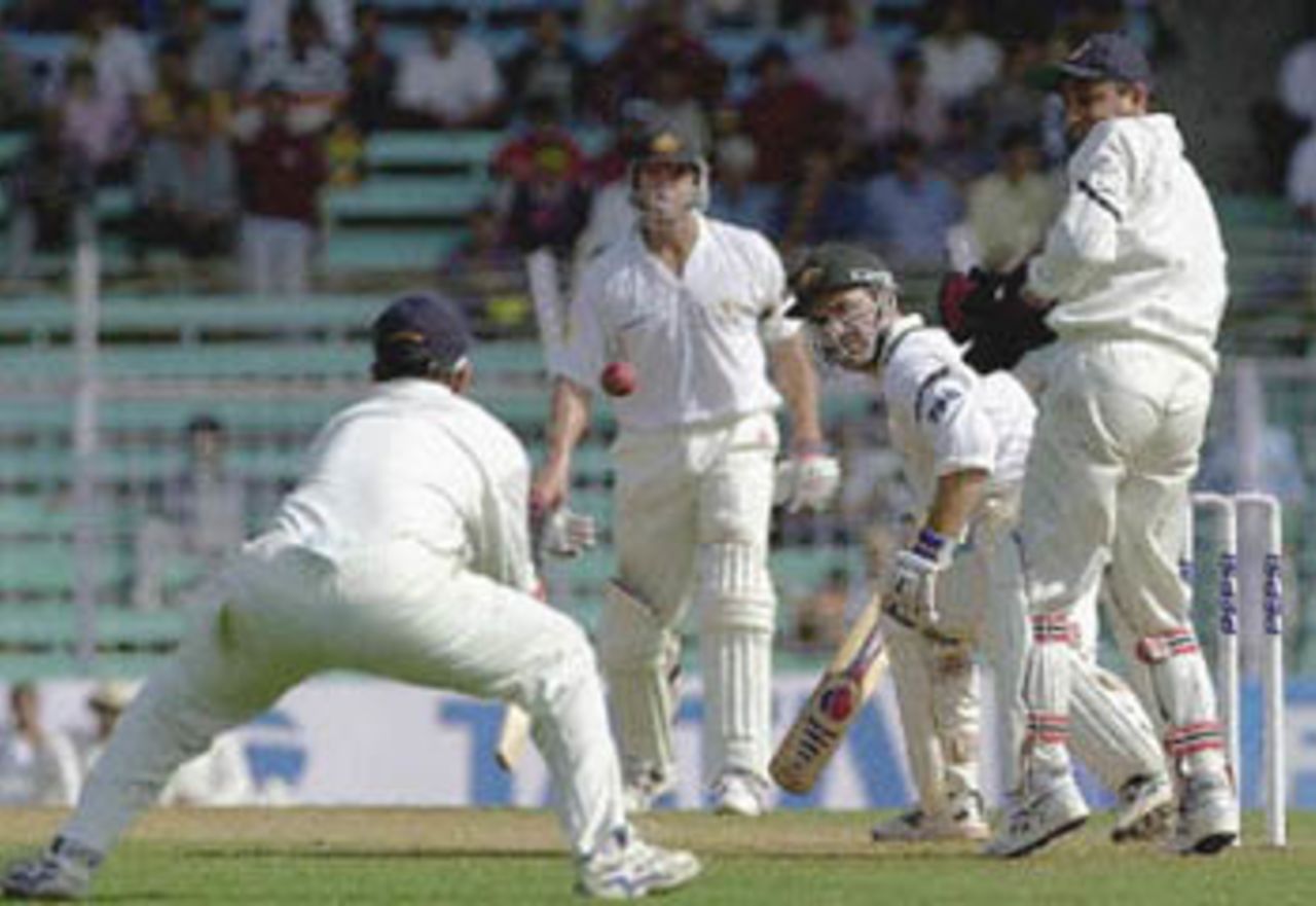Indian player Rahul Dravid (L) stretches out his hand to take a catch to dismiss Australian batsman Justin Langer(2nd from R) off the bowling of Indian spinner Harbhajan Singh as Matthew Hayden (2nd from L) and Indian wicketkeeper Nayan Mongia (R) look on during the the second day's play of the first test match between India and Australia at Wankhade stadium in Bombay 28 February 2001. Singh took three early wickets to restrain Australia at 123 for 5 in reply to India's modest first inning's total of 176 runs.