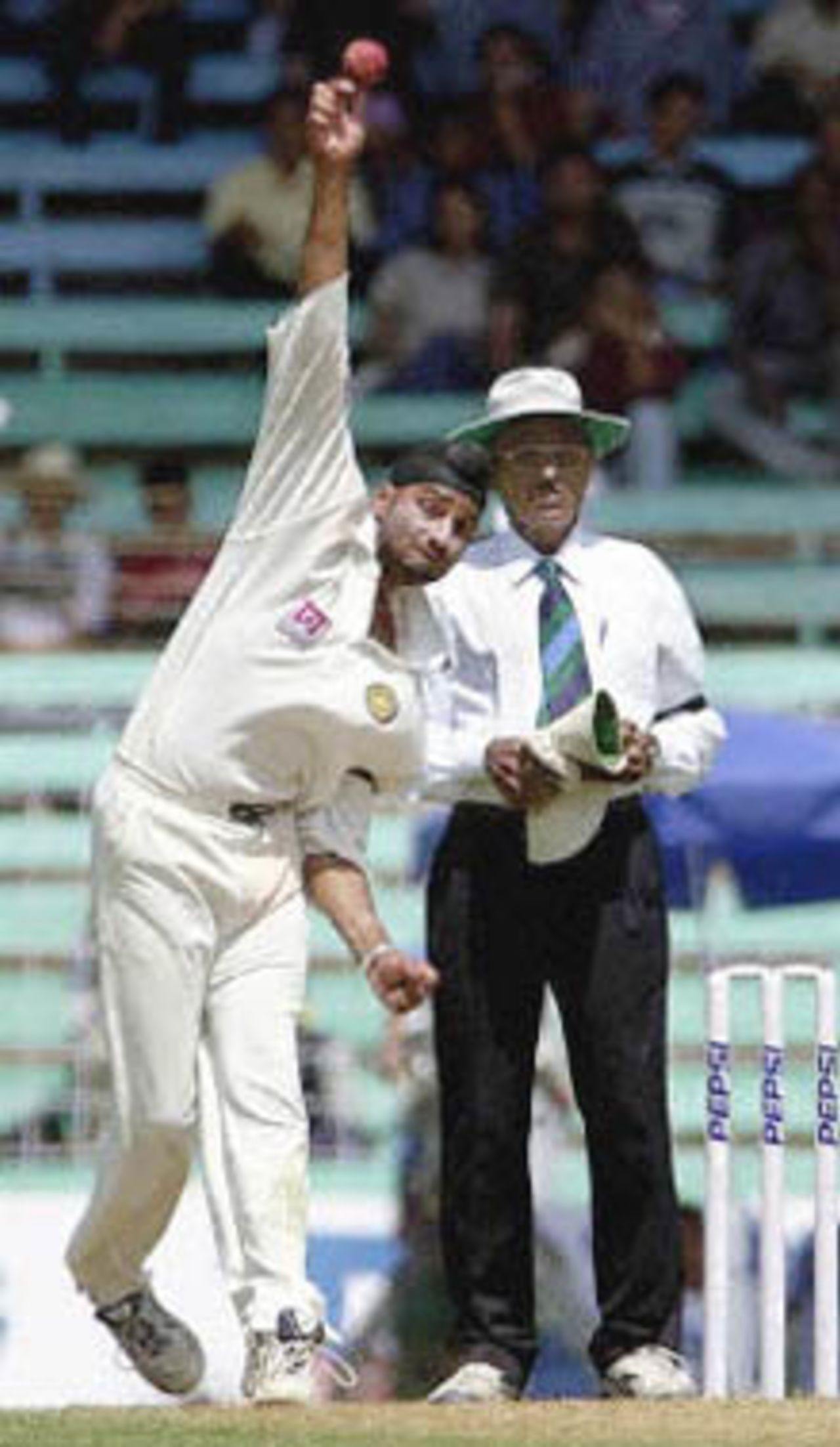 Indian spinner Harbhajan Singh bowls to Australian batsman Mark Waugh (not in the picture) as the umpire looks on during second day's play of the first test match between India and Australia at Wankhade stadium in Bombay 28 February 2001. Harbhajan Singh claimed three early Australian wickets however with the help of centuries from batsmen Matthew Hayden and Adam Gilchrist and put Australia in a strong position at 319 for 6 after lunch in reply to India's 176 runs.