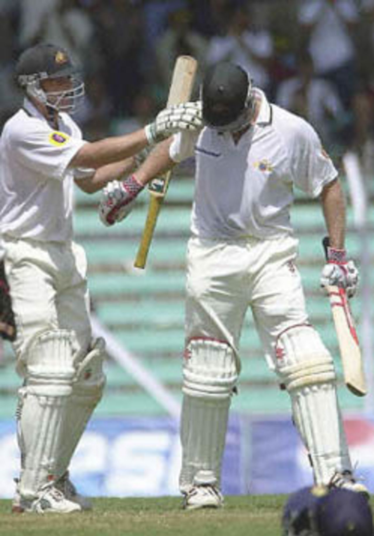 Australian batsman Adam Gilchrist (L) congratulates team-mate Matthew Hayden after Hayden completed his century on the second day of the first test match between India and Australia at Wankhade stadium in Bombay 28 February 2001. Both Gilchrist and Hayden hit centuries to put Australia in strong position at 295 for 5 after lunch in reply to India's 176 runs.