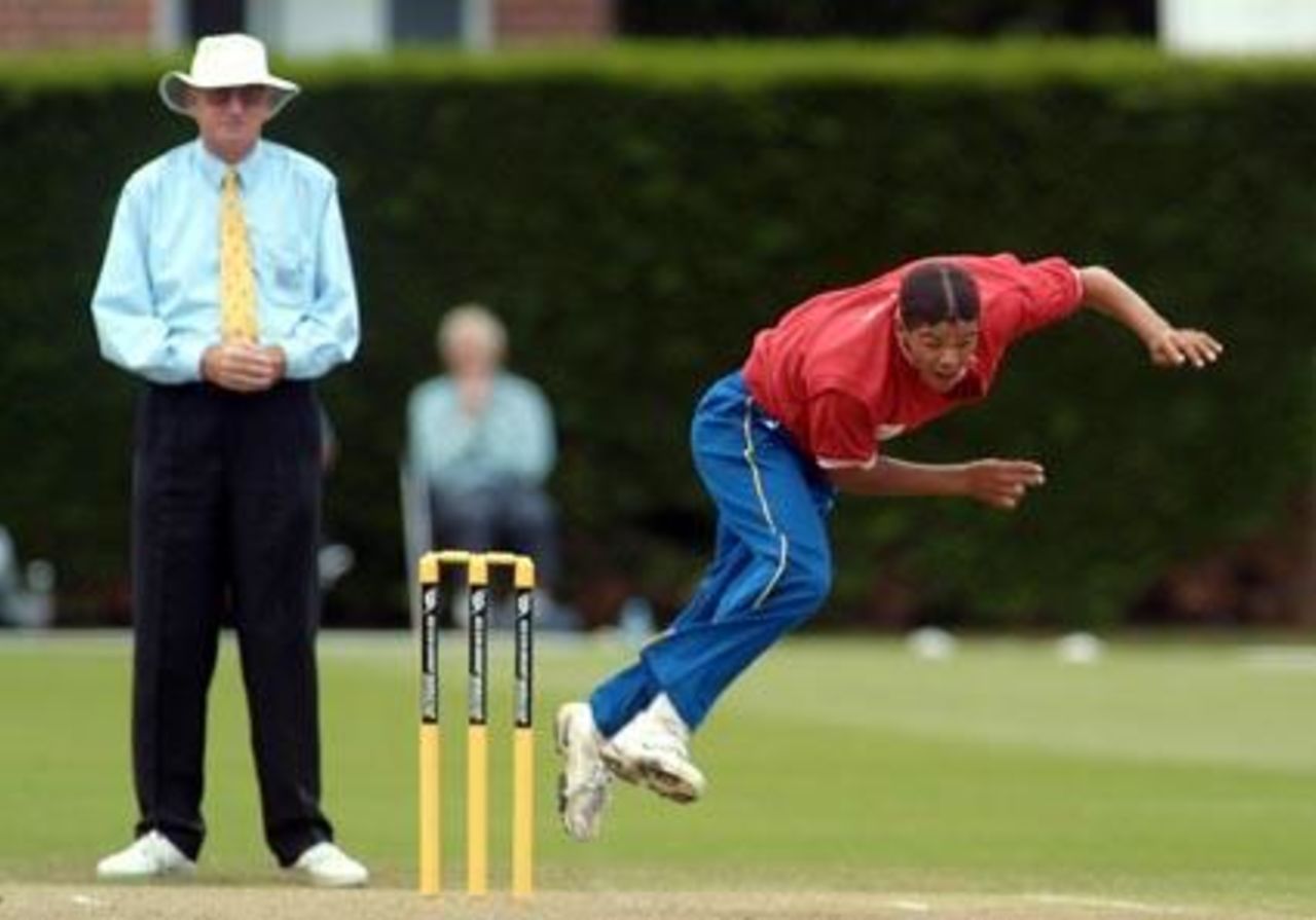 Namibia Under-19 bowler Burton van Rooi delivers a ball during his spell of 3-33 from eight overs. Umpire Tony Cooper from Fiji looks on. 1st ICC Under-19 World Cup Plate Championship Semi Final: Namibia Under-19s v Zimbabwe Under-19s at Lincoln No. 3, Lincoln, 4 February 2002.