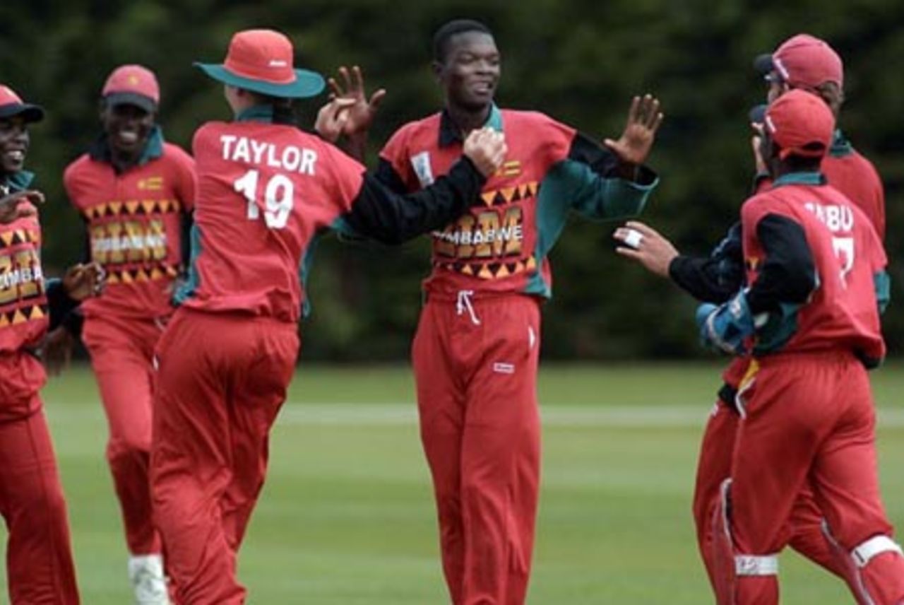 Zimbabwe Under-19 bowler Waddington Mwayenga is congratulated by team-mates for dismissing Namibia Under-19 batsman Stephan Swanepoel, caught by Brendon Taylor (third from left, facing away) for eight. 1st ICC Under-19 World Cup Plate Championship Semi Final: Namibia Under-19s v Zimbabwe Under-19s at Lincoln No. 3, Lincoln, 4 February 2002.