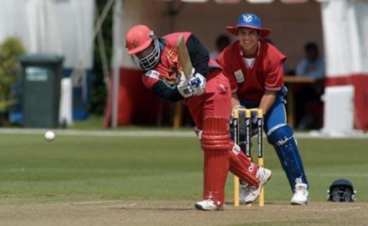 Zimbabwe Under-19 batsman Stuart Matsikenyeri drives a delivery down the ground during his innings of 22. Namibia Under-19 wicket-keeper Hugo Ludik looks on. 1st ICC Under-19 World Cup Plate Championship Semi Final: Namibia Under-19s v Zimbabwe Under-19s at Lincoln No. 3, Lincoln, 4 February 2002.