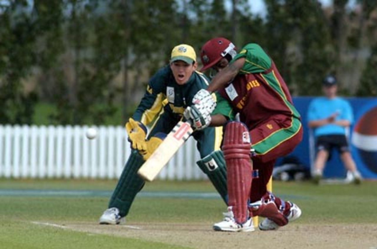 West Indies Under-19 batsman Tonito Willett drives through the covers during his innings of 83. Australia Under-19 wicket-keeper Adam Crosthwaite looks on. 2nd ICC Under-19 World Cup Super League Semi Final: Australia Under-19s v West Indies Under-19s at Bert Sutcliffe Oval, Lincoln, 6-7 February 2002 (7 February 2002).
