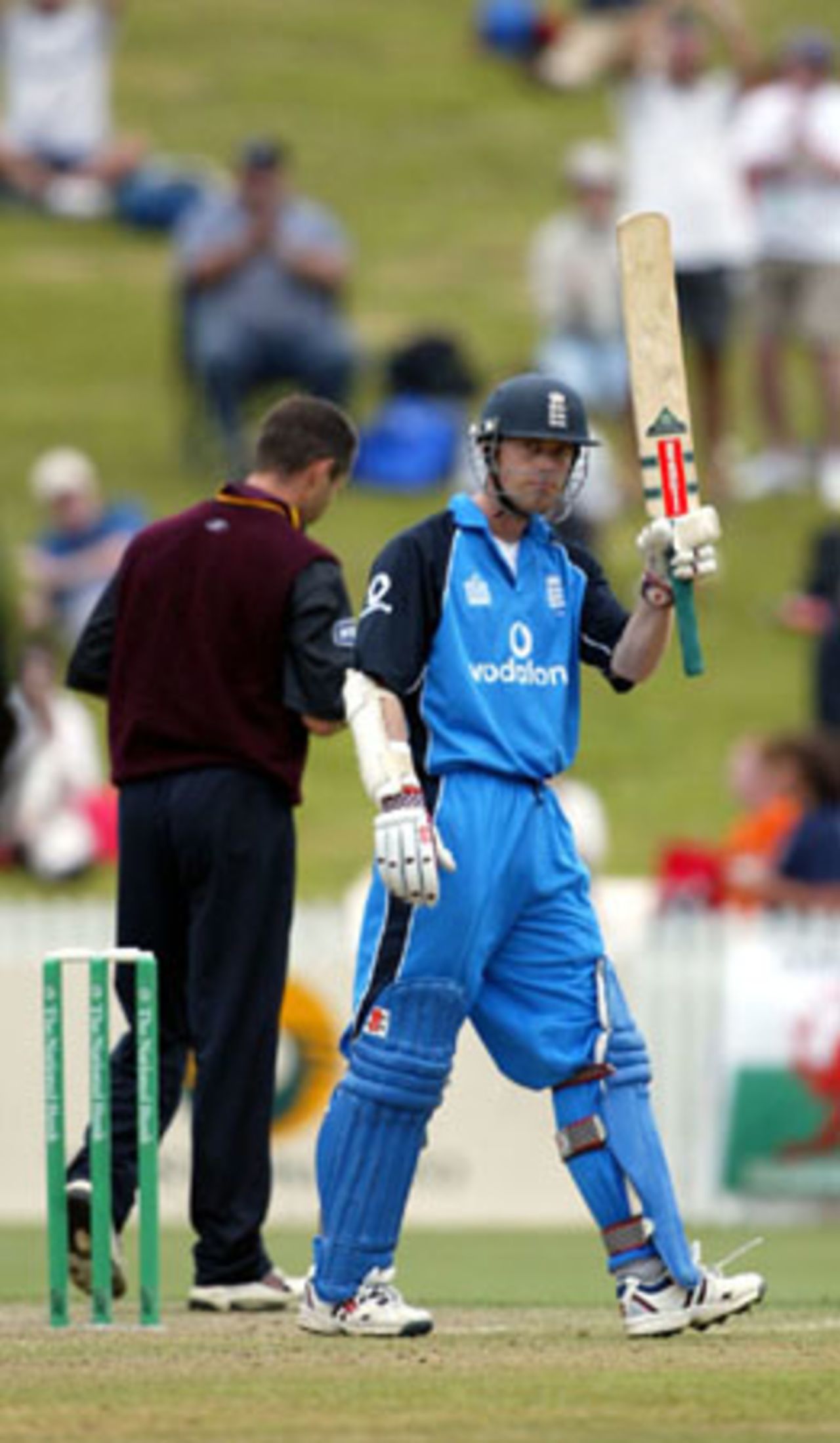 England batsman Nick Knight raises his bat to celebrate reaching his century. Knight went on to score 126. Northern Districts bowler Matthew Hart (facing away) is in the background. Tour match: Northern Districts v England at WestpacTrust Park, Hamilton, 8 February 2002.
