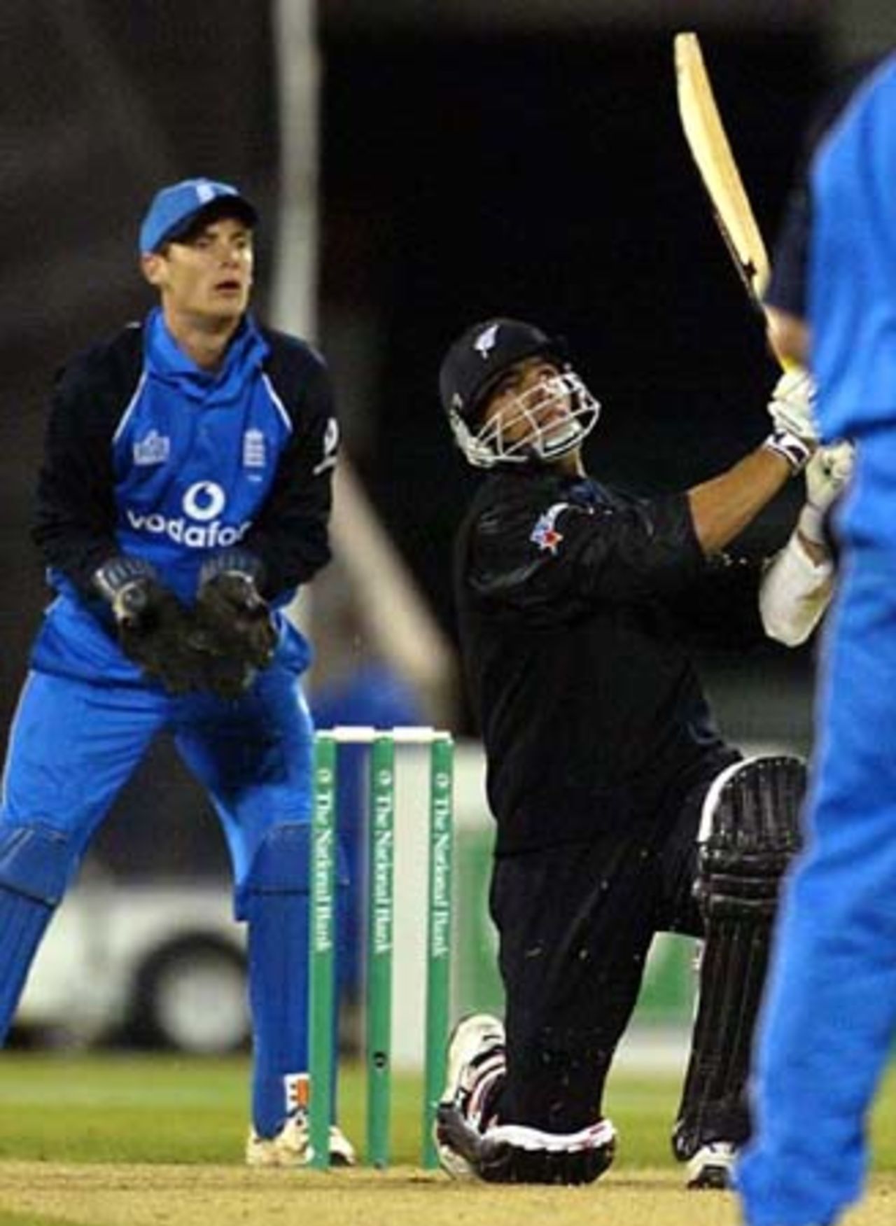 New Zealand batsman Andre Adams hits a six from England bowler Ashley Giles during his innings of 28 not out. Wicket-keeper James Foster looks on. 1st ODI: New Zealand v England at Jade Stadium, Christchurch, 13 February 2002.