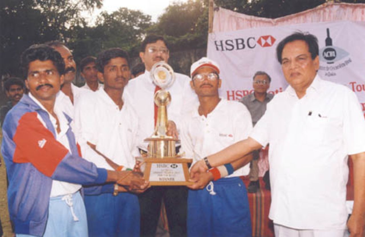 TNCA Honourary Secretary Ashok Kumbhat presents the HSBC trophy to the Karnataka skipper