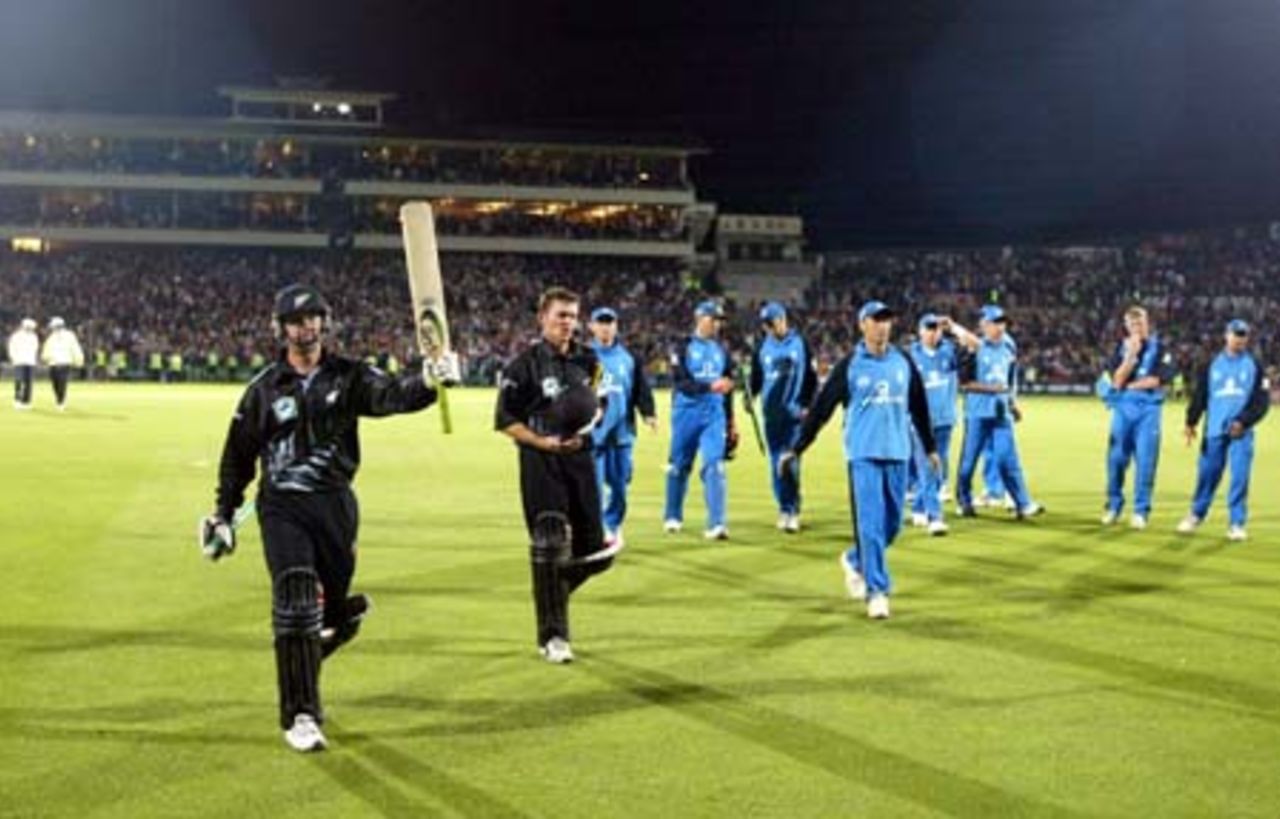 New Zealand batsman Nathan Astle raises his bat to acknowledge the crowd as he walks from the field. Astle scored 122 not out. Batting partner Lou Vincent and members of the England team also walk from the field. 5th ODI: New Zealand v England at Carisbrook, Dunedin, 26 February 2002.