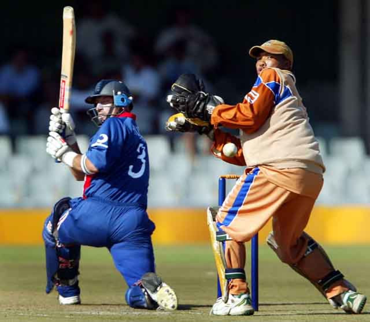 England's skipper Nasser Hussain sweeps behind as Border Bears' wicket keeper Abongile Sodumo, World Cup warm up match at Buffalo Park in East London, South Africa, February 6, 2003.