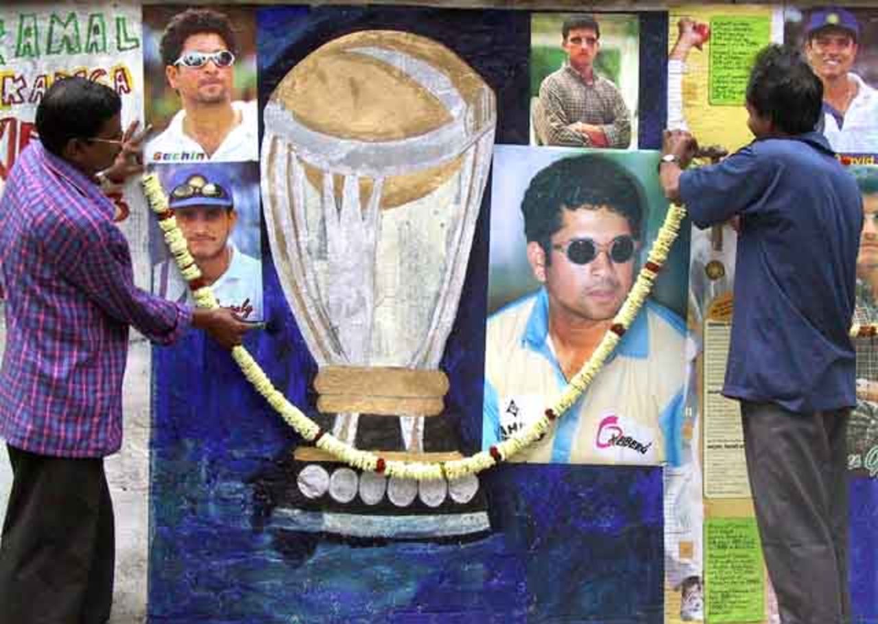 Indian cricket enthusiast's set-up a garland on a wall decorated with pictures of Indian cricket players in Calcutta February 7, 2003