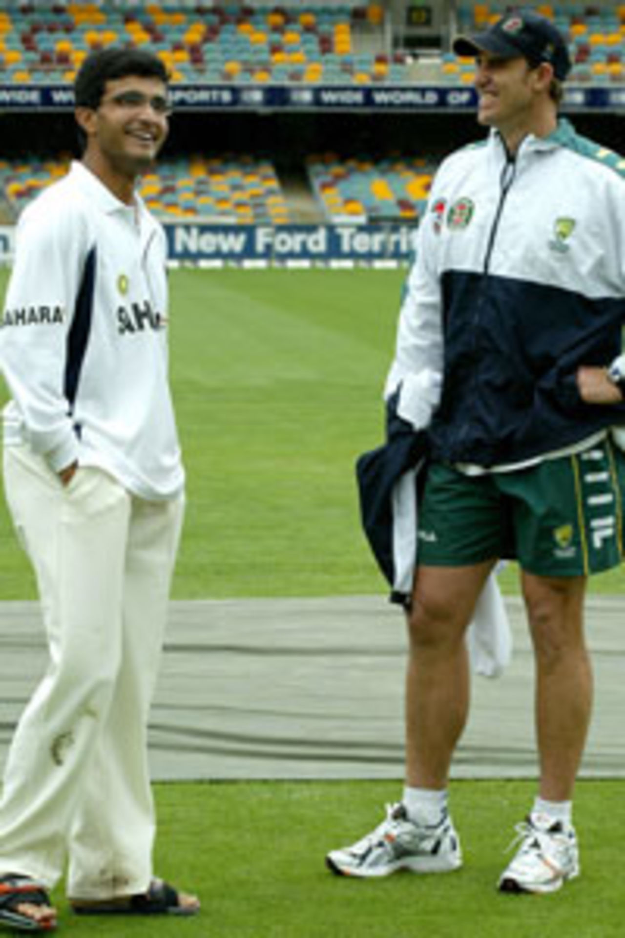 Indian captain Sourav Ganguly (L) and Matthew Hayden (R) from Australia, share a joke alongside a covered centre pitch, as rain delays the start of play on day three of the first cricket Test between India and Australia, at the Gabba cricket ground in Brisbane, 06 December 2003. Australia are set to resume on a score of 9 for 323.