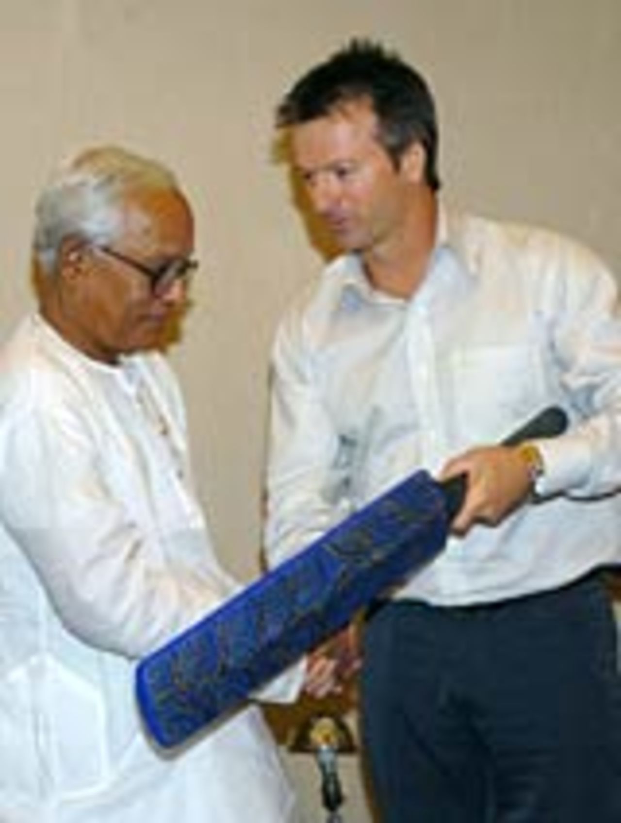 Former Australian captain Steve Waugh presents a cricket bat crafted by aborigines to Buddhadev Bhattacharya, the chief minister of West Bengal, February 15, 2005