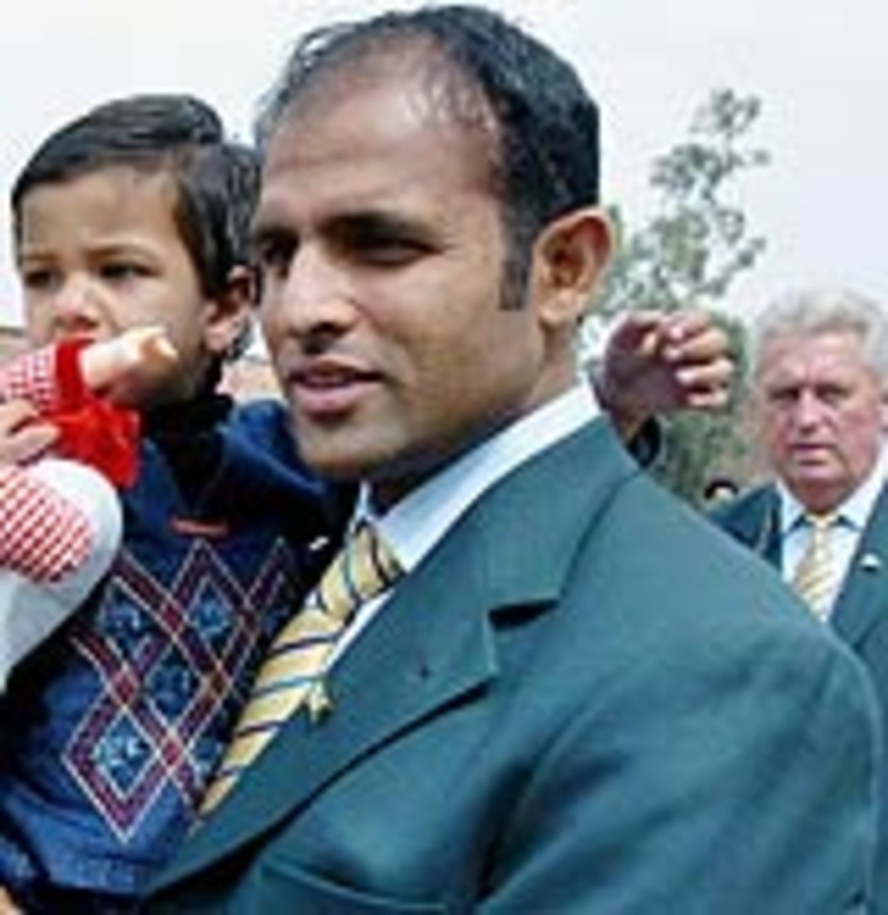 Naved-ul-Hasan carrying his daughter as Bob Woolmer looks on, Lahore, February 28, 2005