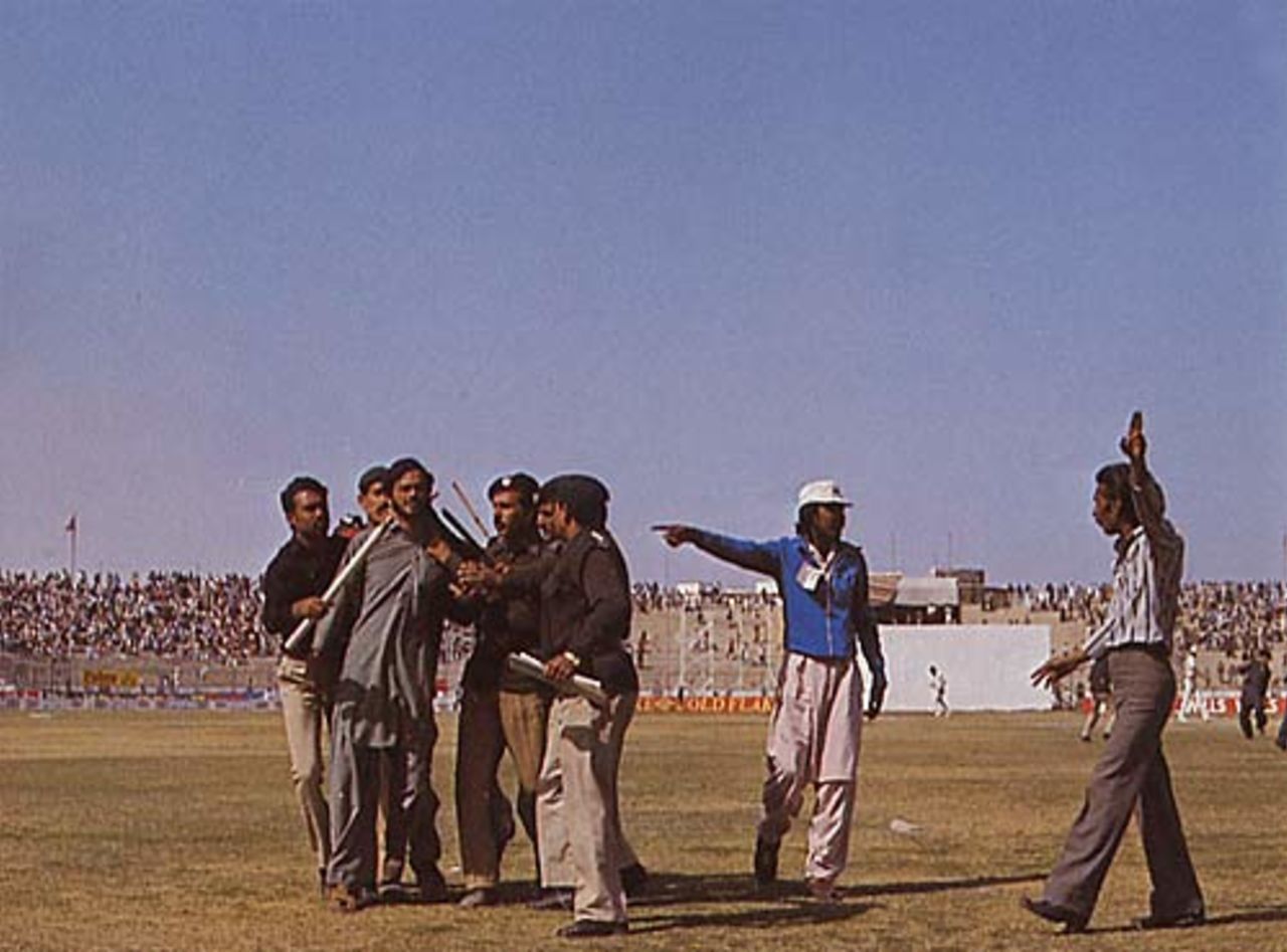 A demonstrator at Karachi is led off after spectators dug up the wicket, Pakistan v India, 1982-83
