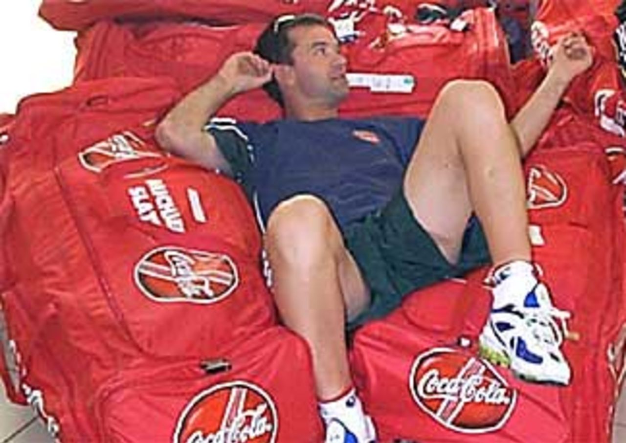 Adam Dale rests on the teams luggage during the long trip to the West Indies, 1998/99