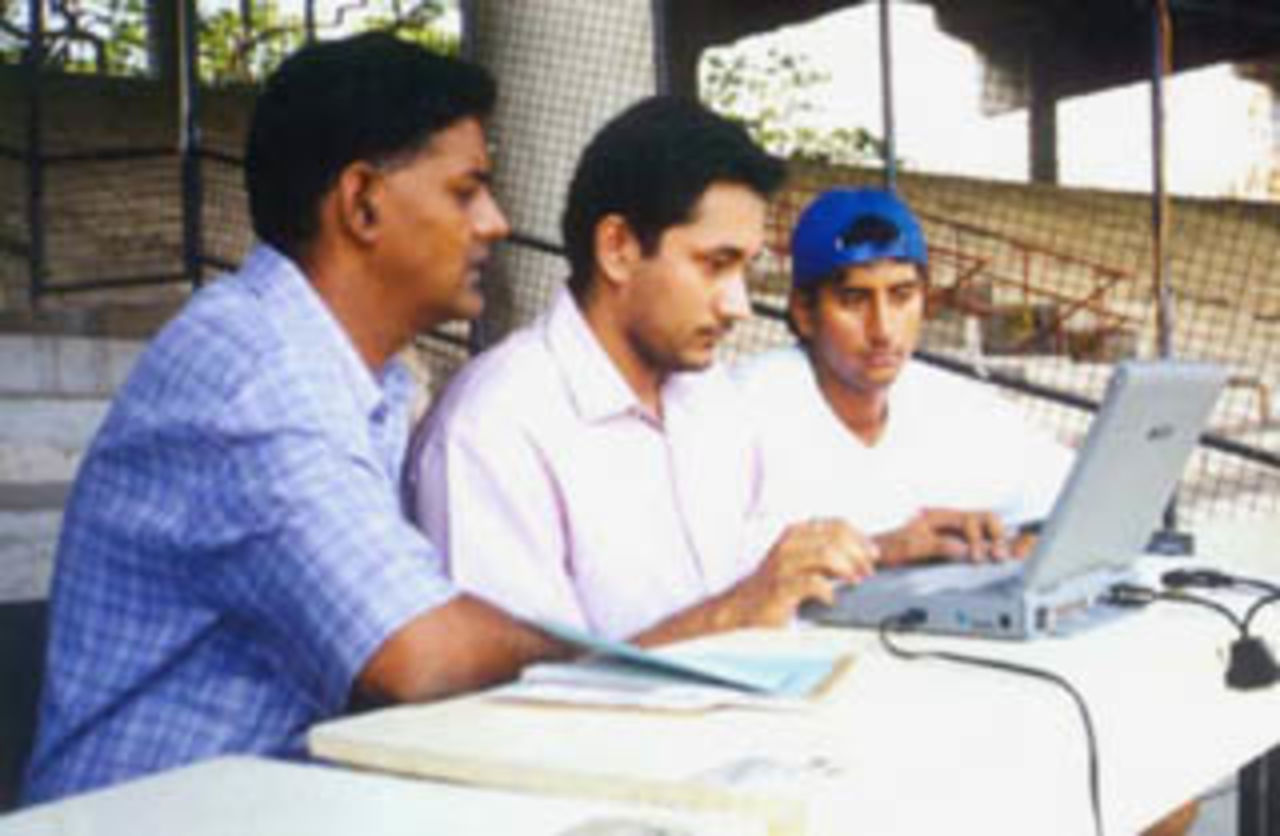 Sadagopan Ramesh watches the question posed on irc channel cricket, S Jagadish (CricInfo) reads out the question as TR Kashyappan looks on.