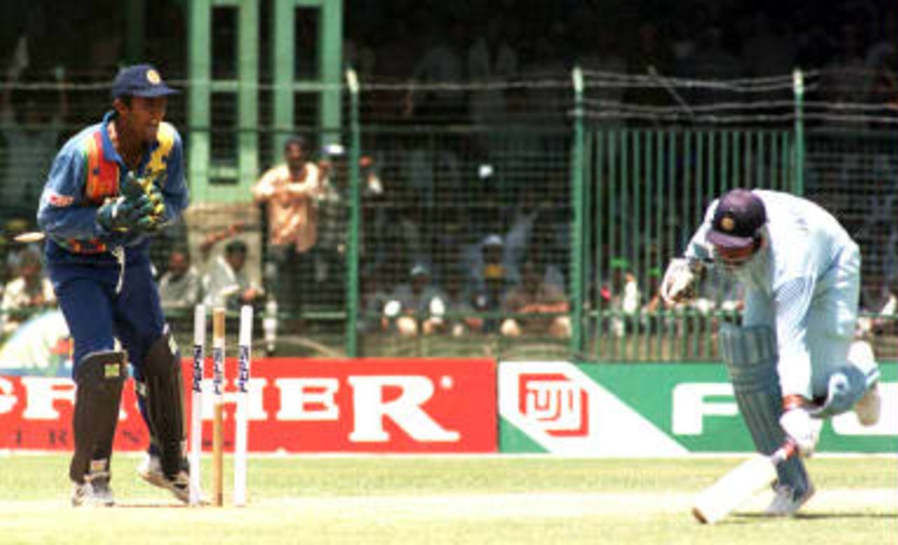 Bails fly as India's captain Ajay Jadeja narrowly makes it to the crease on his way to a century , as Sri Lanka wicketkeeper Hashan Tillekaratne looks on 30 March 1999, at the Nehru Stadium in Pune.