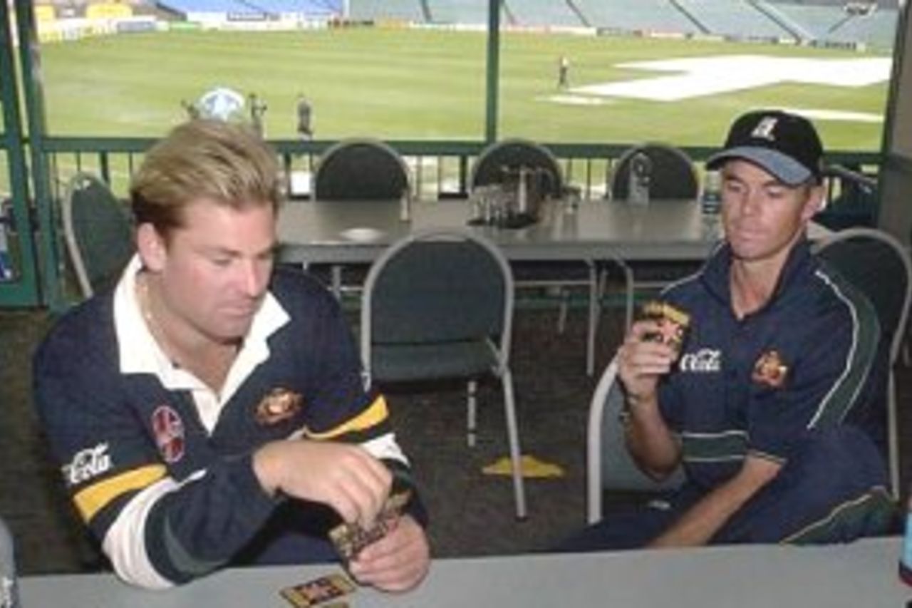 14 Mar 2000: Australian spin bowler Shane Warne (left) and batsman Greg Blewett pass the time playing cards during a rain delay on day 4 of the first test between Australia and New Zealand at Eden Park,Auckland, New Zealand. Play was officially abandoned at 2.00pm local time. Warne only requires one more wicket to become Australia's most successful wicket taker.
