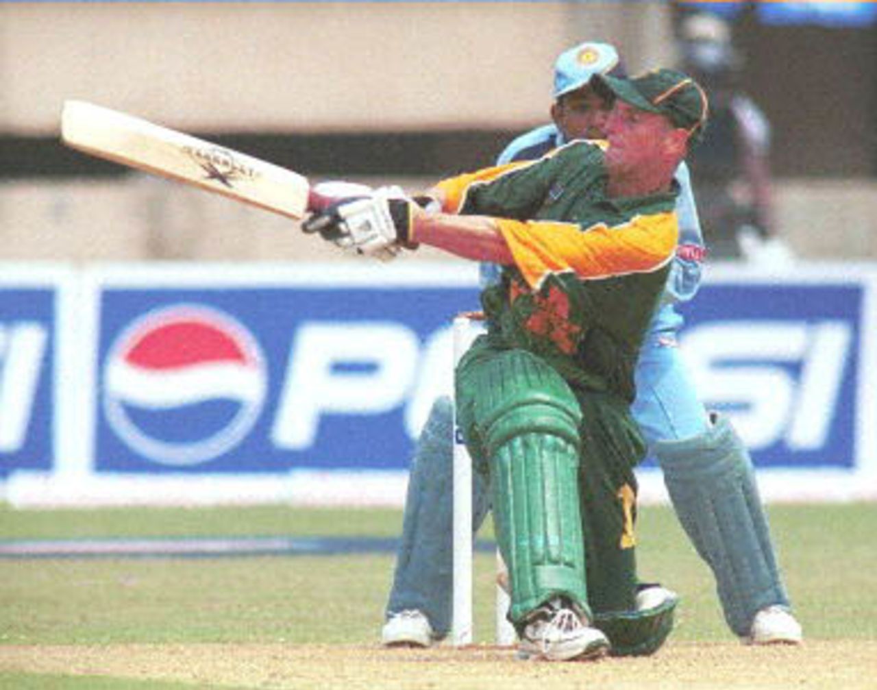 South African batsman Gary Kirsten sweeps a ball on his way to making 115 runs as Indian wicketkeeper Samir Dighe (partly covered) looks on during the first one-day international cricket match between India and South Africa in Cochin 09 March 2000. Despite centuries from both openers Kirsten and Herschelle Gibbs India went onto win the match by 3 wickets