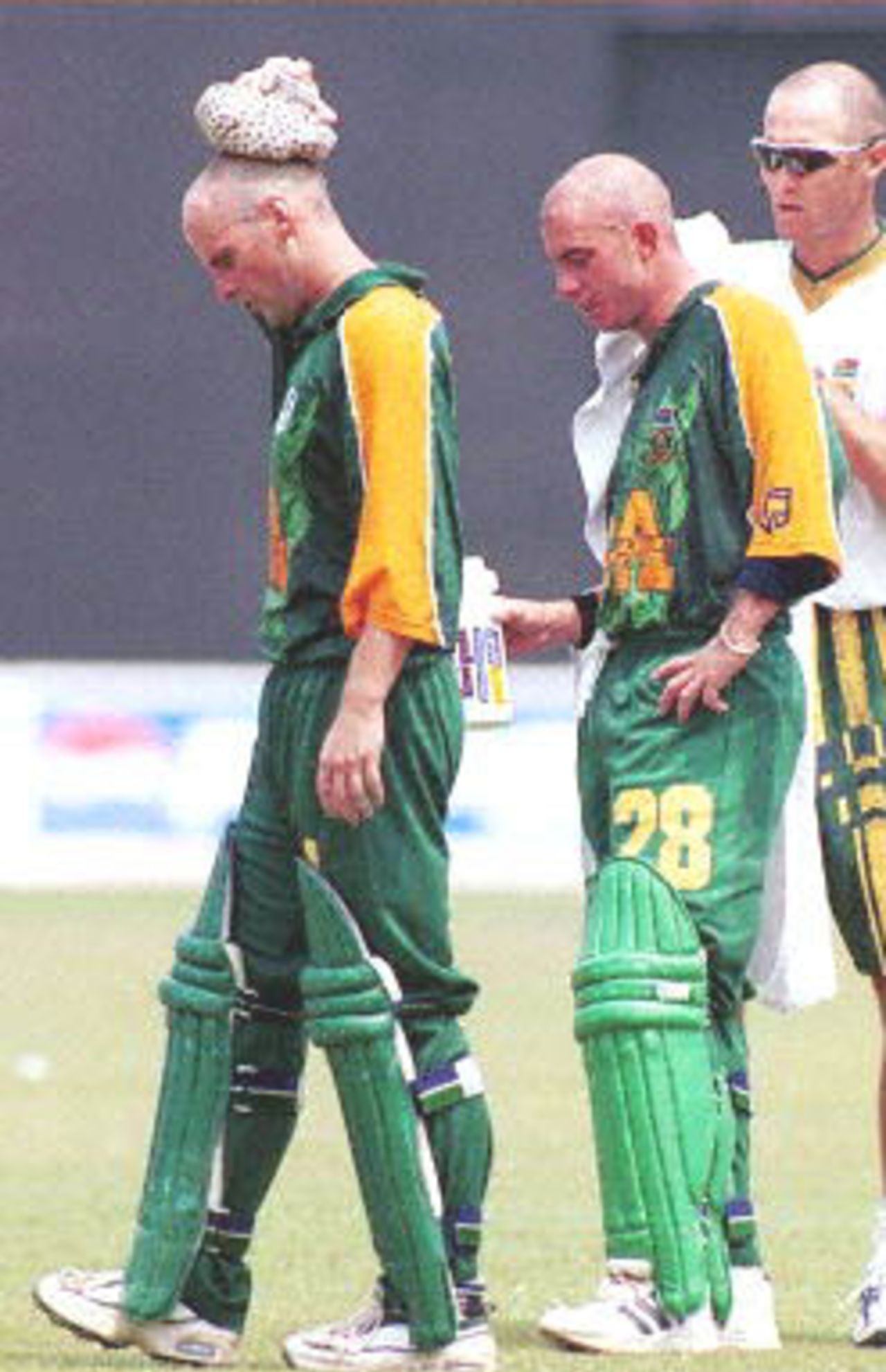 South African batsman Gary Kirsten (L) puts an ice pack on his head as the team physiotherapist attends to team-mate Herschelle Gibbs (C) during the drink's break in the first one-day international cricket match between India and South Africa in Cochin 09 March 2000. Despite centuries from openers Kirsten and Gibbs India went onto win the match by 3 wickets