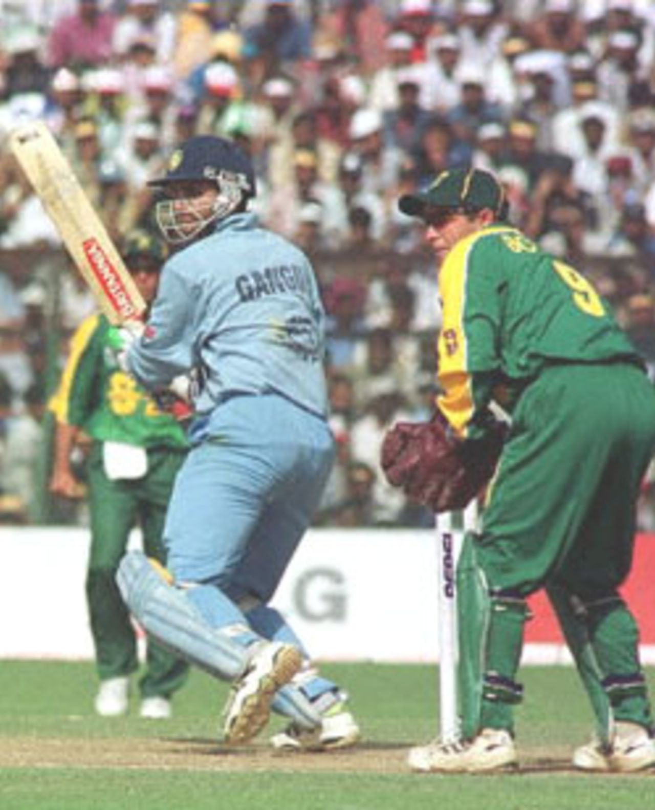 Indian skipper Sourav Ganguly (L) hits a boundary as South African wicketkeeper Mark Boucher looks on during the second match of the one day series between India and South Africa at Keenam Stadum, Jamshedpur 12 March 2000. India won the match by seven wickets. Sourav Ganguly scored a century and became man of the match