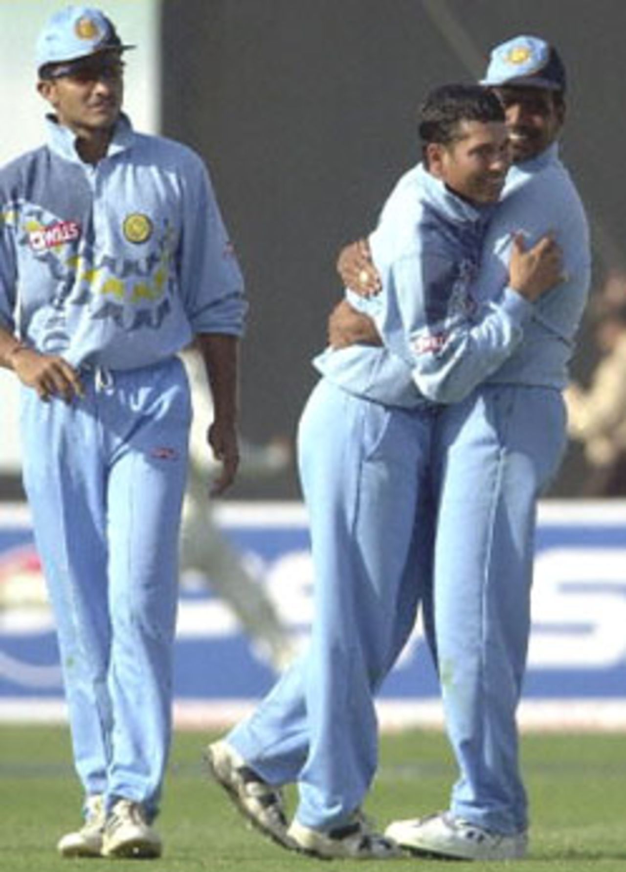 Former Indian captain Sachin Tendulkar (C) being congratulated by team-mate Sunil Joshi (R) after Tendulkar claimed the important wicket of South African captain Hansie Cronjie, as team captain Sourav Ganguly (L) walks past during the third one-day international cricket match between South Africa and India played at Faridabad, 15 March 2000. Tendulkar went on to take four wickets but could not prevent India from losing to South Africa by two wickets. The five match series stands at 2-1 in favour of India.