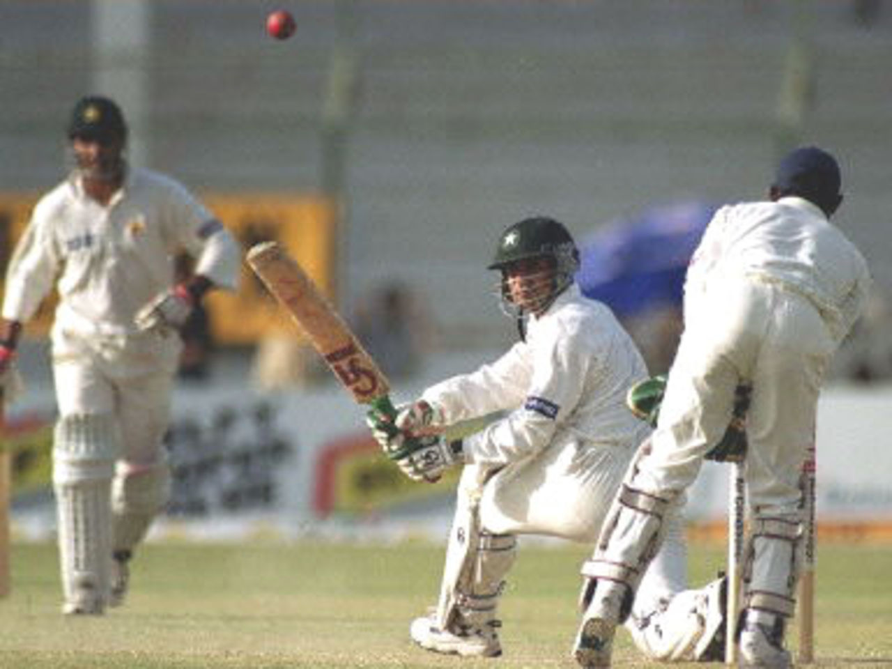 Pakistani skipper Moin Khan (C) sweeps for a boundary off Sri Lankan spinner Muttiah Muralitharan on the third day of the third and final cricket Test in Karachi, 14 March 2000. Khan was on 51 as Pakistan were 375-7.