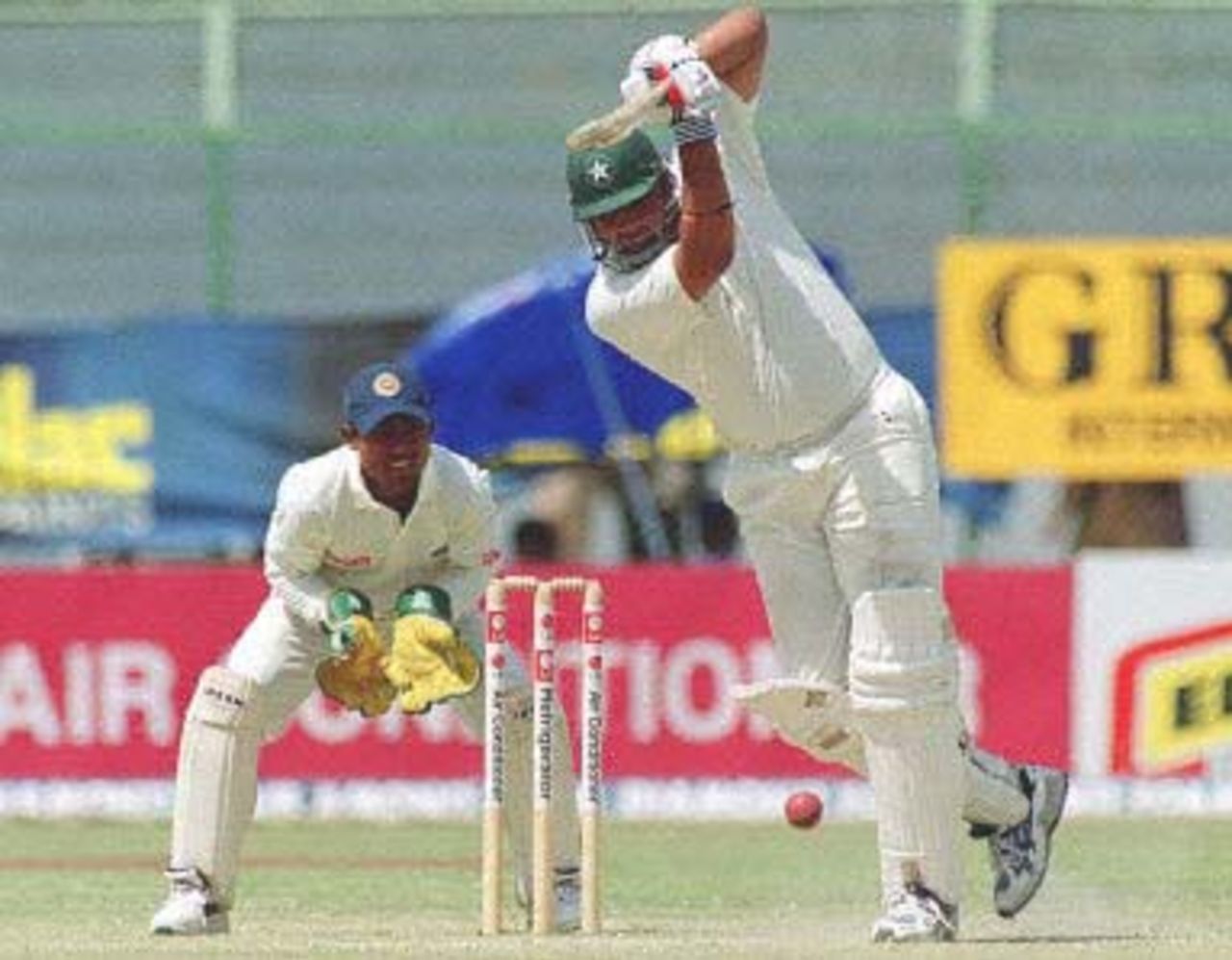 Pakistani middle order batsman Inzamam-ul-Haq drives the ball off Sri Lankan spinner Muttiah Muralitharan for a boundary, while Sri Lankan wicket keeper Romesh Kaluwitharana watches, on the third day of the third and last cricket Test in Karachi, 14 March 2000. Haq guided Pakistan to a commanding position by scoring 138 runs. At stumps Pakistan were 375-7 having overall lead of 404.