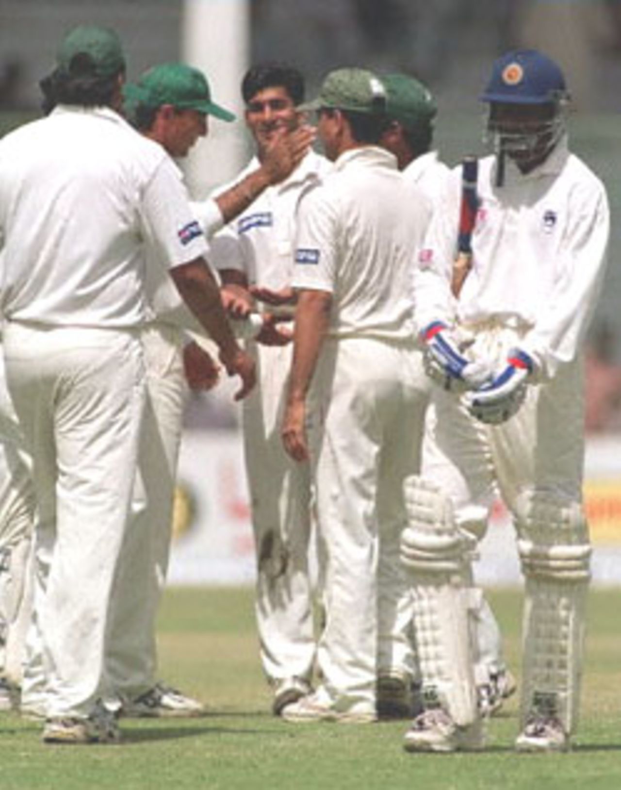 Pakistani debutant paceman Irfan Fazil (C) is greeted by other teammates on his first wicket as Sri Lankan batsman Russel Arnold (R) leaves ground on the second day of the third and final cricket Test in Karachi, 13 March 2000. Sri Lanka were 201-7 at tea in reply of Pakistan's first inning total of 256 all out.