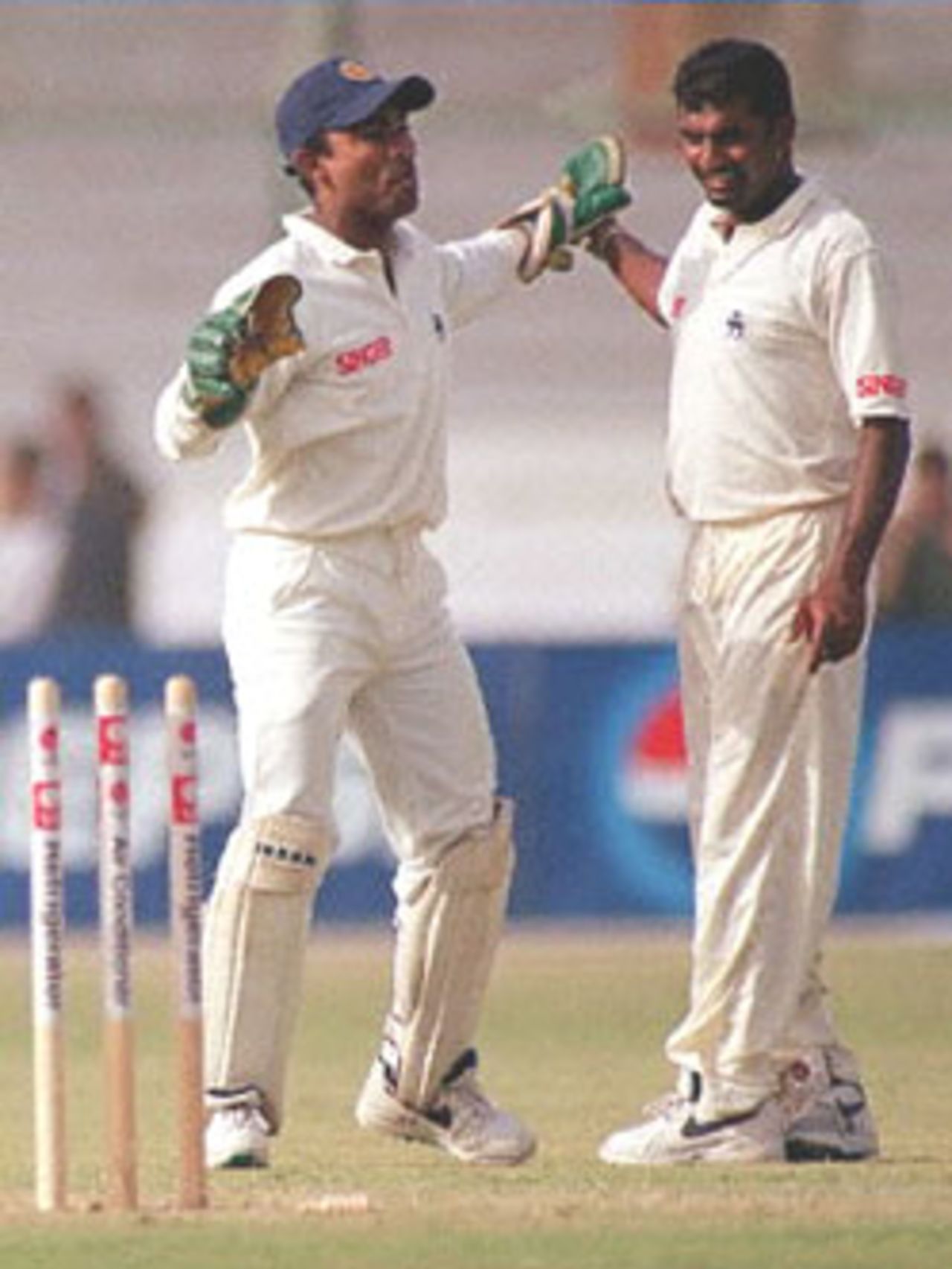 Sri Lankan spinner Muttia Murlitharan (R) celebrates with wicketkeeper Romesh Kaluwitharana after taking his fourth wicket of the inning in Karachi 12 March 2000 during the first day of the third Test against Pakistan. Murlitharan took 4-89 in the first inning.