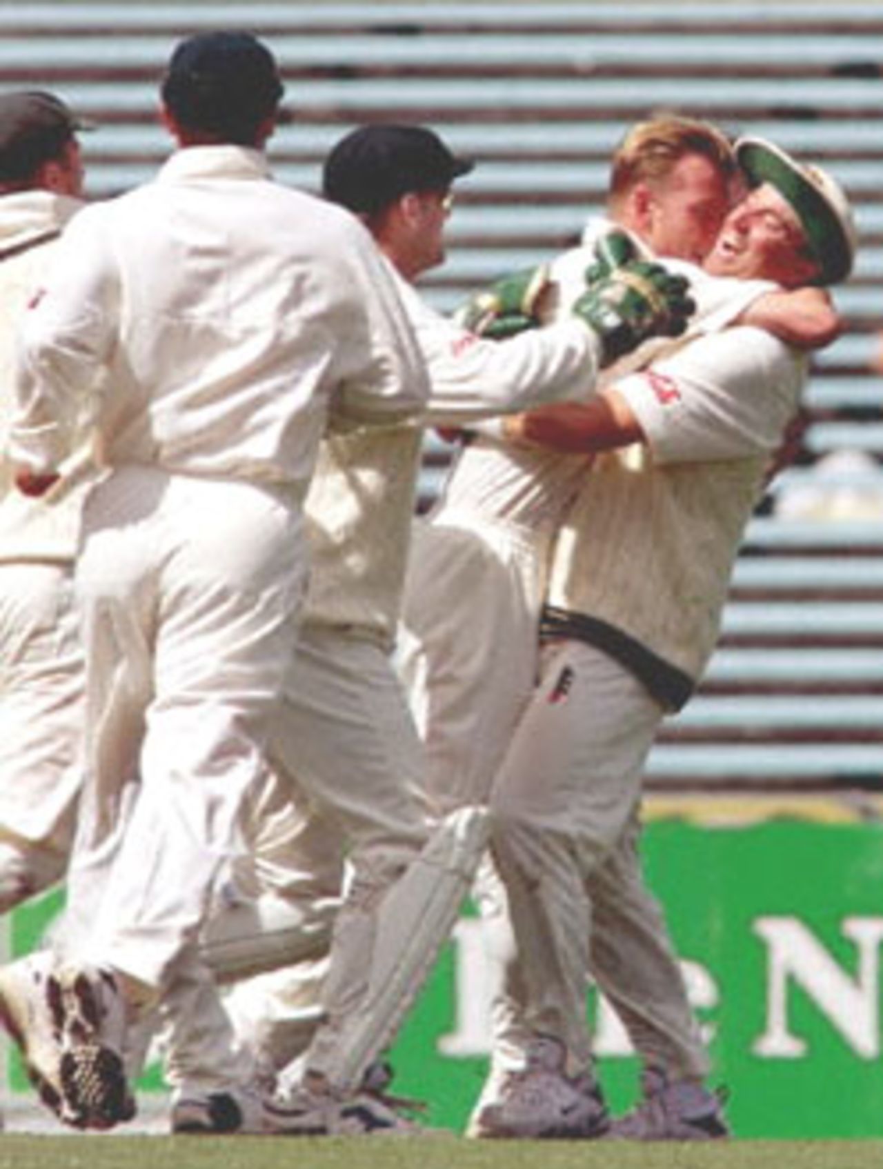 Australian Shane Warne (R) is hugged by teammate Brett Lee (2nd R) after catching New Zealand batsman Craig McMillan off Lee's bowling on the final day of the first Test Match at Eden Park in Auckland 15 March 2000. Australia defeated New Zealand by 62 runs and in doing so equalled the Australian record for consecutive test victories as well as Warne passing the Australian test wicket-taking record of 355 wickets held by paceman Dennis Lille.