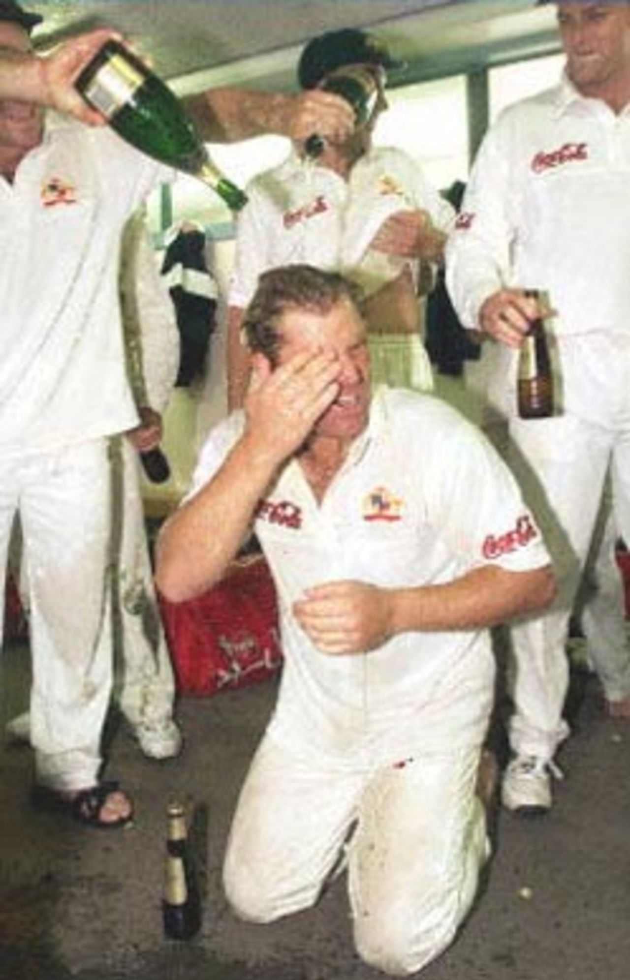 Australian spinner Shane Warne (C) is sprayed with champagne as he and his teammates celebrate after Warne took the wicket of New Zealand batsman Paul Wiseman, his 356th career dismissal, to break the Australian Test wicket-taking record of 355 held by former paceman Dennis Lille, on the last day of the first Test match between Australia and New Zealand at Eden Park in Auckland 15 March 2000. Australia defeated New Zealand by 62 runs and in doing so also equalled the Australian record for consecutive Test victories at eight.