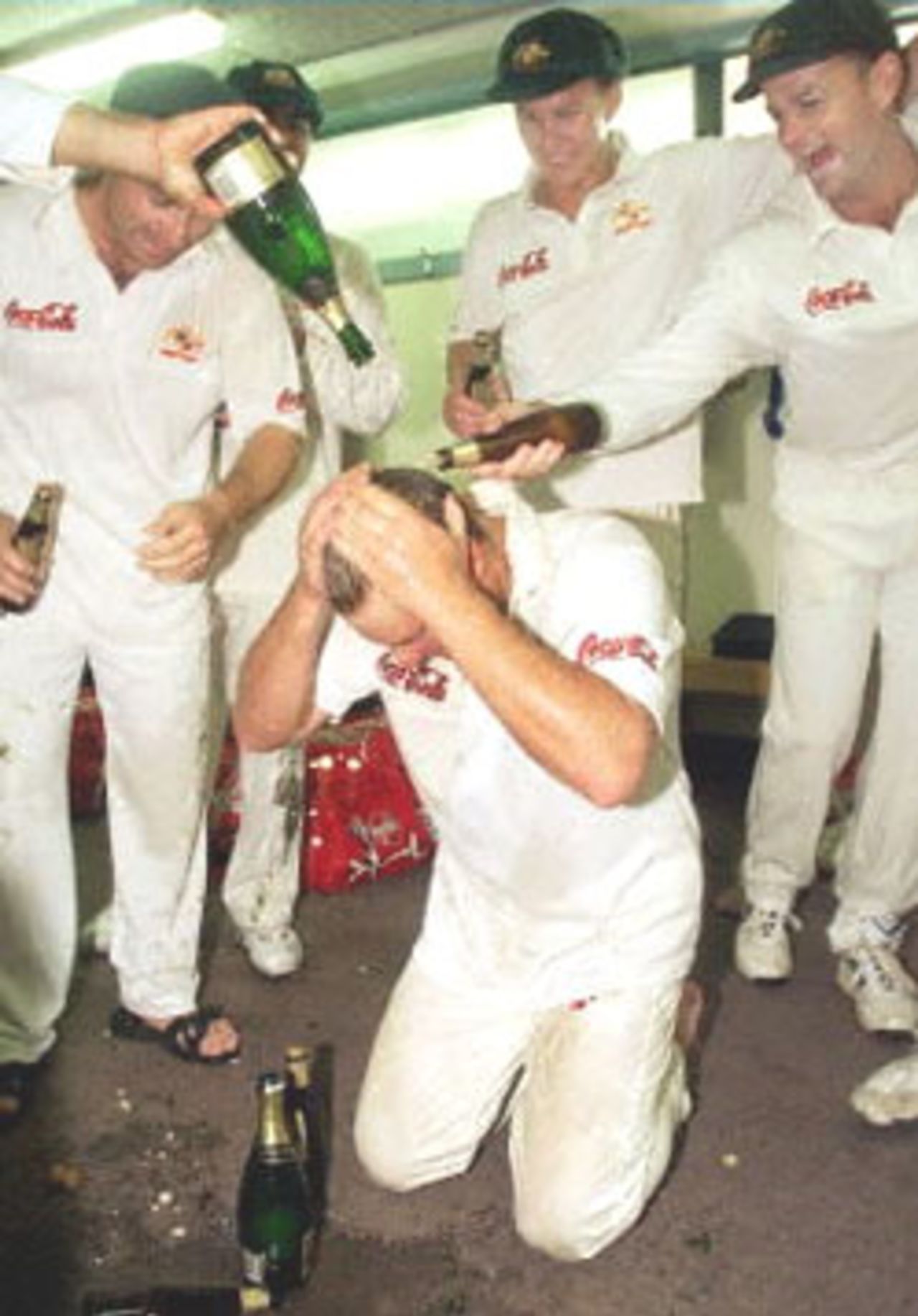 Australian spinner Shane Warne (C) is sprayed with champagne as he and his teammates celebrate after Warne took the wicket of New Zealand batsman Paul Wiseman, his 356th career dismissal, to break the Australian Test wicket-taking record of 355 held by former paceman Dennis Lille, on the last day of the first  Eden Park in Auckland 15 March 2000. Australia defeated New Zealand by 62 runs and in doing so also equalled the Australian record for consecutive Test victories at eight.