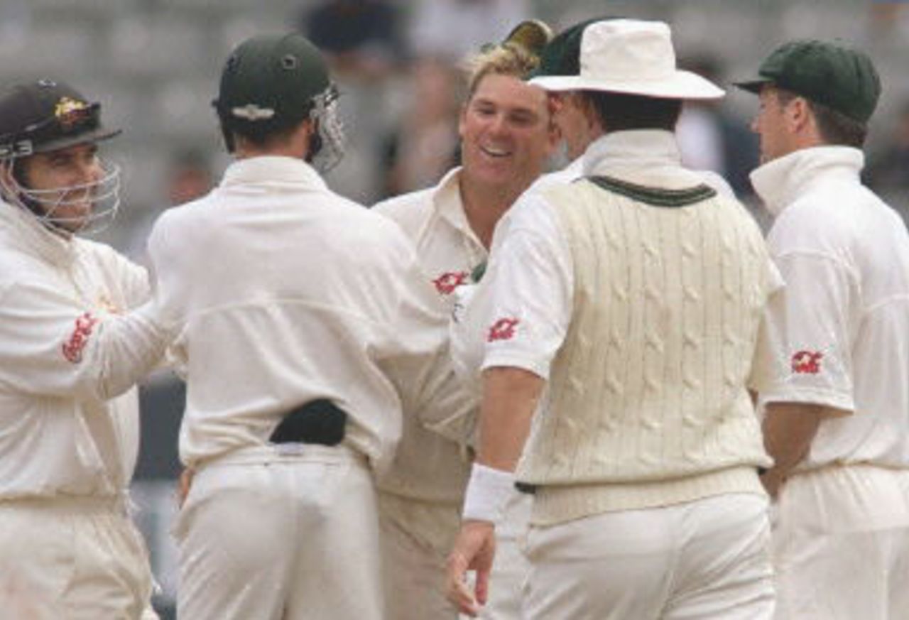Australian spinner Shane Warne (C) is congratulated by his teammates after taking the wicket of New Zealand batsman Craig McMillan as Warne closes in on the Australian Test wicket record held by Dennis Lillee on the second day of the first Test match being played at Eden Park in Auckland 12 March 2000. Australia was dismissed for 214 in their first innings and dismissed New Zealand for 163 for a 51 run lead.