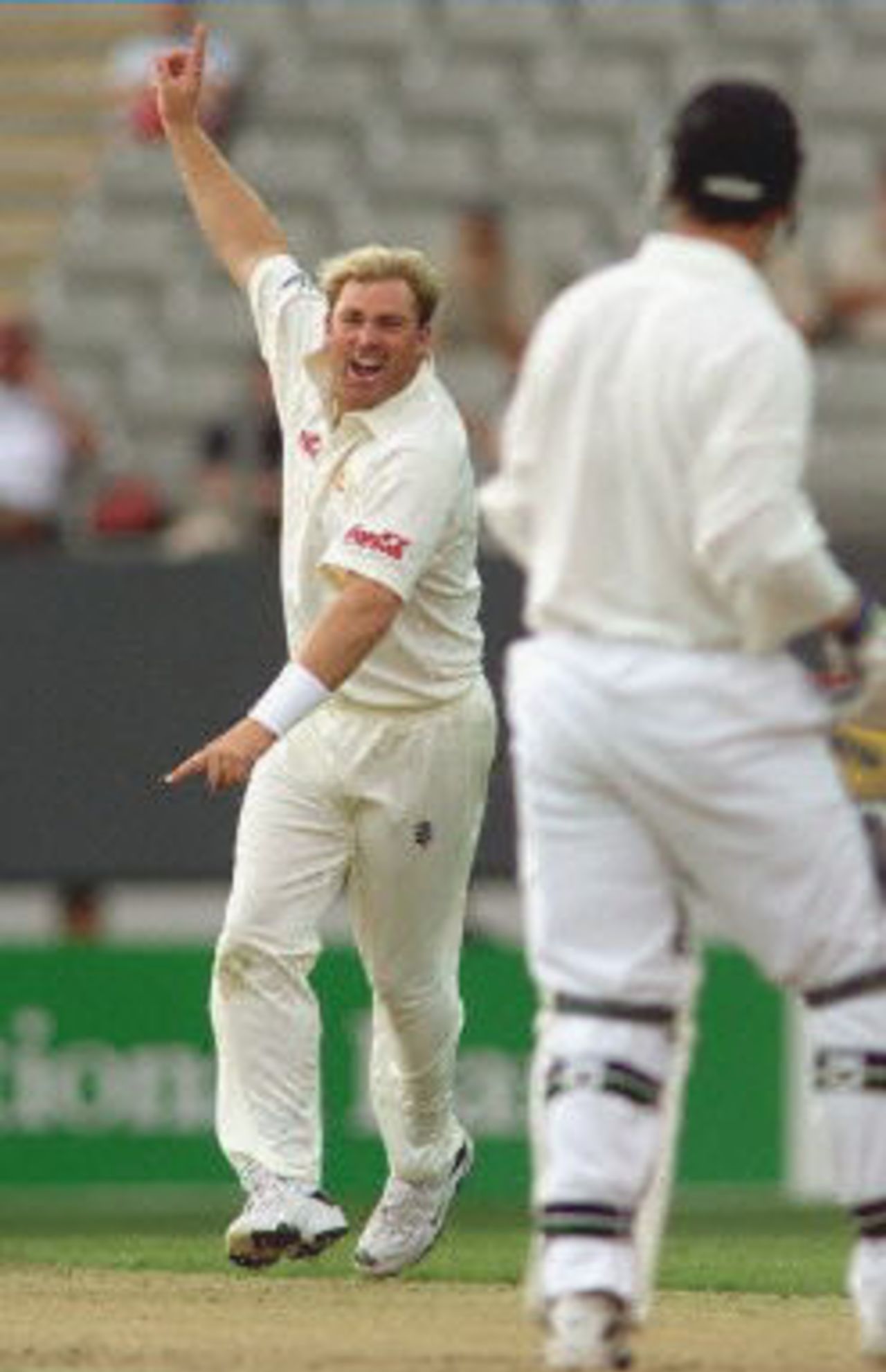 Australian spinner Shane Warne (L) celebrates dismissing New Zealand batsman Matthew Sinclair (R) on the first day of the first Test Match at Eden Park in Auckland 11 March 2000. Australia was dismissed for 214 in their first innings and in reply New Zealand is in trouble at 25-4 at stumps.
