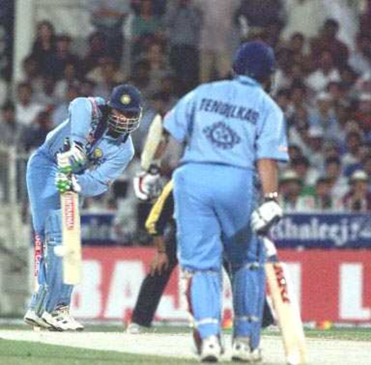 Indian captain Saurav Ganguly (L) in action, as his partner Sachin Tendulkar (R) watches on, during the Champions Cup international at the Sharjah cricket stadium 23 March 2000.