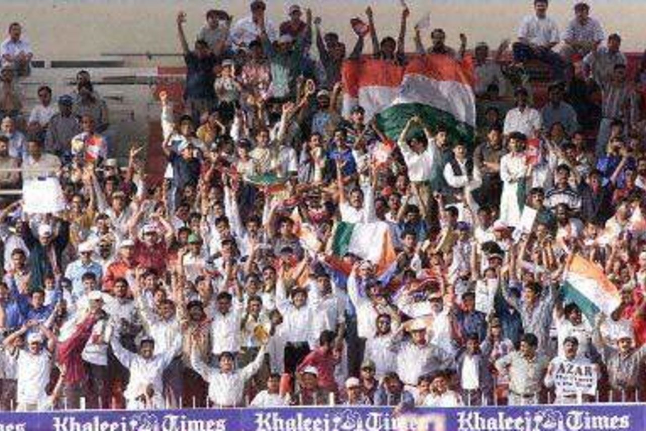 Indian fans cheer their cricket team playing against Pakistan, during the Champions Cup international at the Sharjah cricket stadium 23 March 2000.