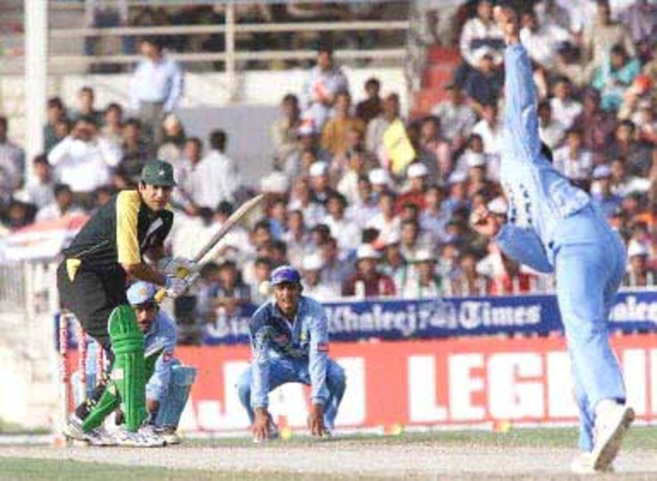 Pakistani batsman Wasim Akram (L) swings at a ball from Indian spinner Anil Kumble during the Champions Cup international at the Sharjah cricket stadium 23 March 2000.