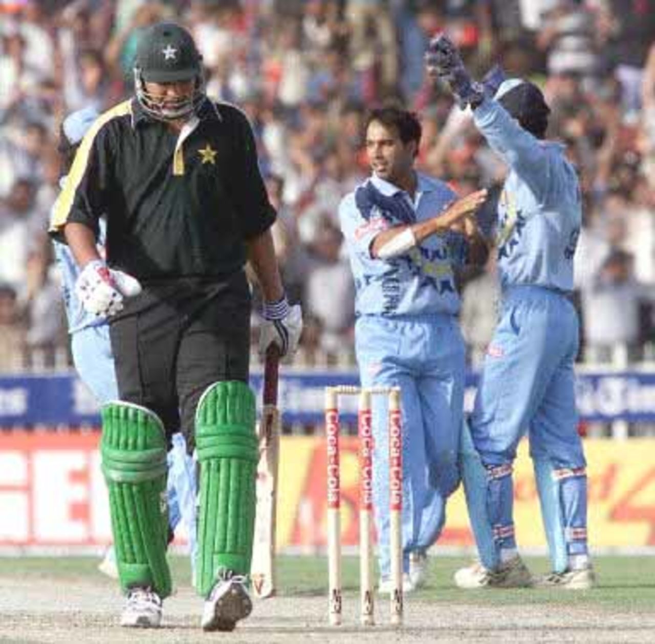 Pakistani batsman Inzamam-ul-Haq (L), walks back dejected after being caught by keeper Karim of the bowling of Robin Singh during the Champions Cup International at the Sharjah cricket stadium 23 March 2000.