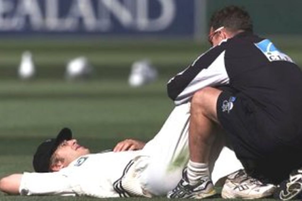 27 Mar 2000: Daniel Vettori of New Zealand being assisted by Mark Harrison, team physio, with an injured back, during day four of the second test between New Zealand and Australia at the Basin Reserve, Wellington, New Zealand.