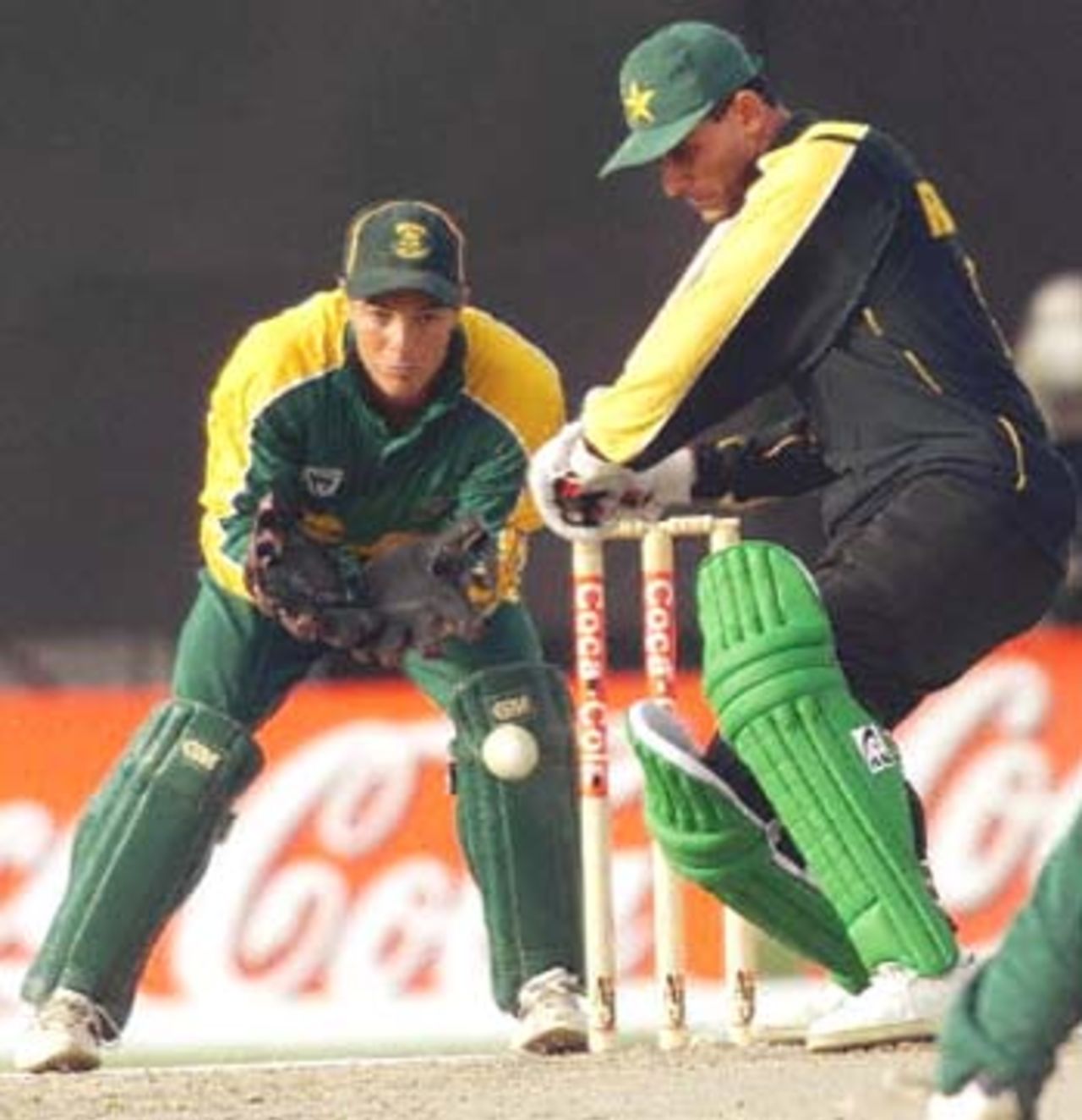 Pakistani Abdur Razzaq (R) bats as South Africa's Mark Boucher looks on at the three-nation Sharjah Cup, 28 March 2000. South Africa shot Pakistan out for 168 in the last match of the preliminary league.