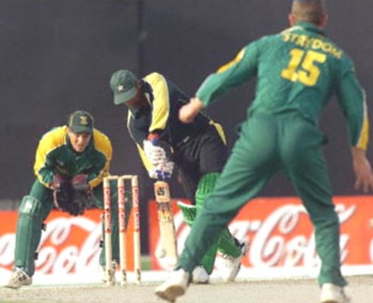 Pakistani Yousuf Youhanna (C) bats against South African bowler Peter Strydom (R), as South African Mark Boucher (L) readies to catch the ball at the three-nation Sharjah Cup, 28 March 2000. South Africa shot Pakistan out for 168 in the last match of the preliminary league.