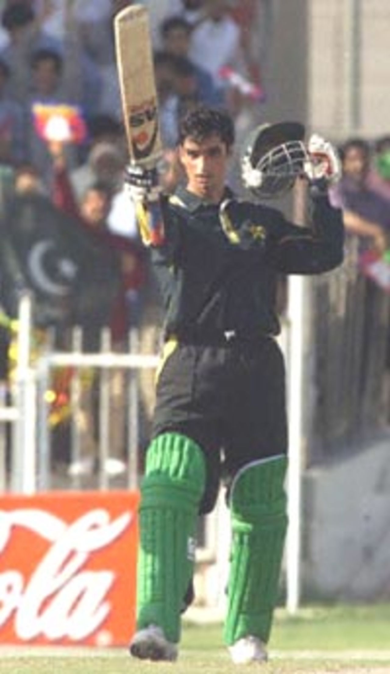Pakistani batsman Imran Nazir raises his bat after reaching the half century mark during the three-nation cricket Sharjah Cup final in Sharjah 31 March 2000