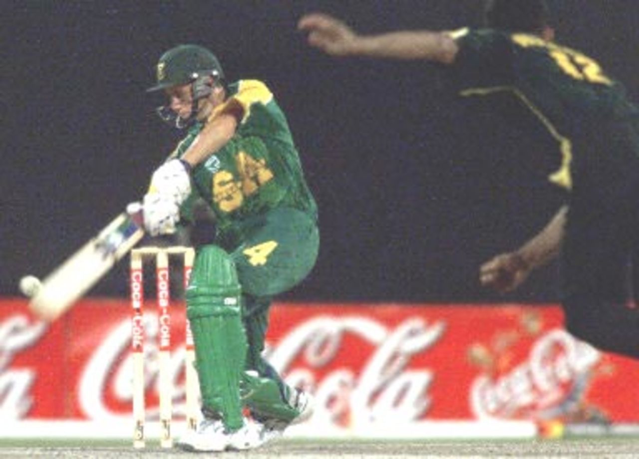 South Africa batsman Mark Boucher (L) smashes the ball from Pakistani bowler Abdur Razzaq (R) during the final in Sharjah 31 March 2000