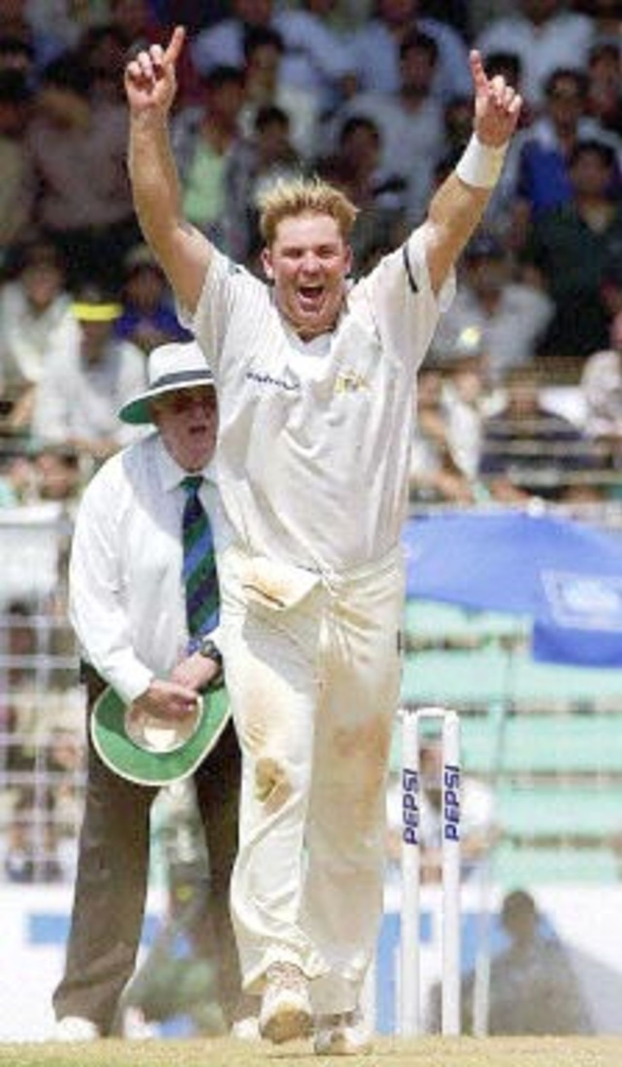 Australian spinner Shane Warne celebrates after taking the wicket of Indian batsman Rahul Dravid (not in picture) as the umpire (behind) looks on during the third day's play of the first Test match between India and Australia at Wankhede stadium in Mumbai 01 March 2001. India were in deep trouble at 202 for 7 by tea and face an almost certain defeat.