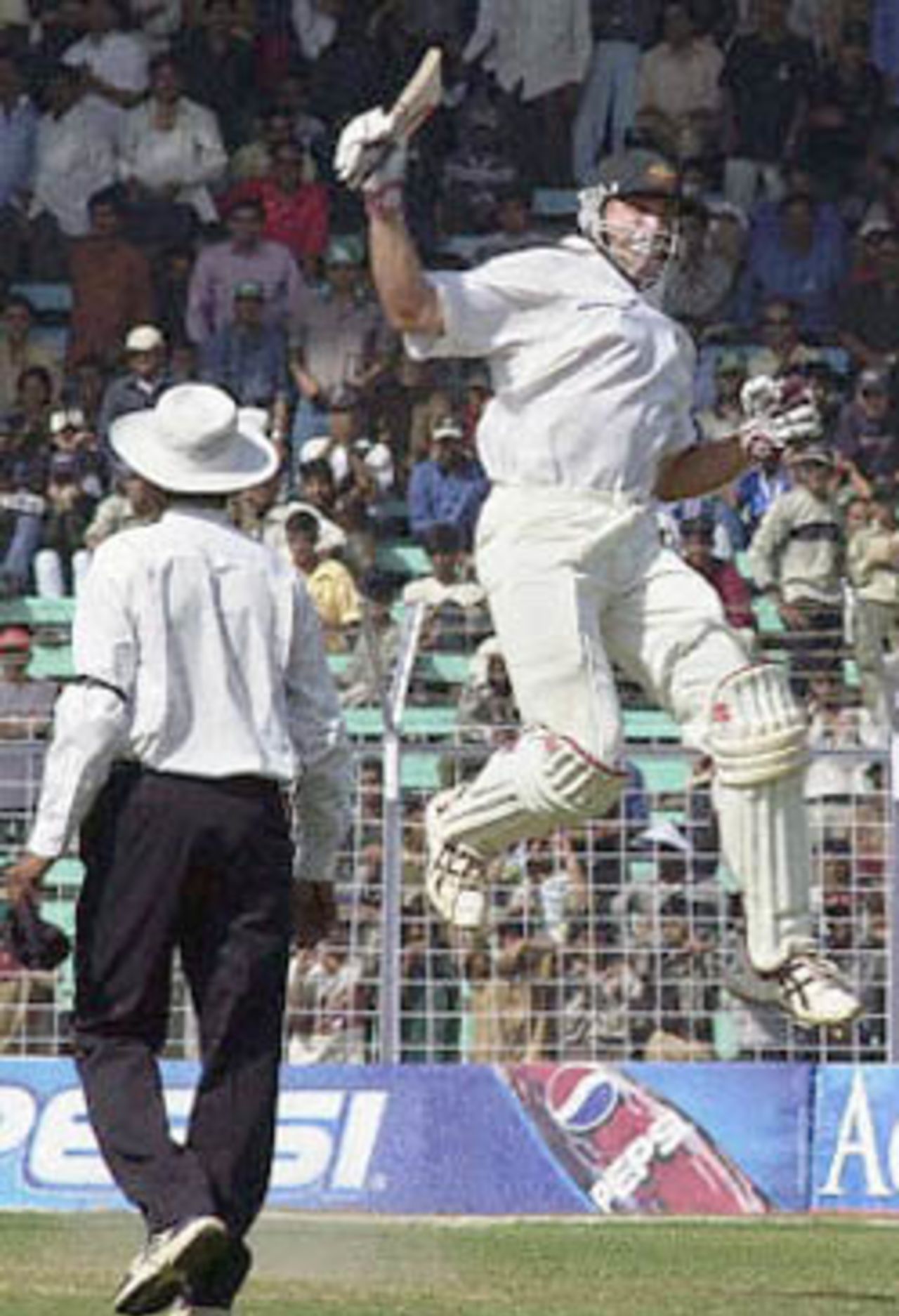 Australian batsman Matthew Hayden jumps in the air with joy after scoring the wining runs against India as the match umpire walks past on the third day of the first test match between India and Australia at the Wankhade Stadium in Bombay 01 March 2001. Australia won the first of the three test match series by 10 wickets.