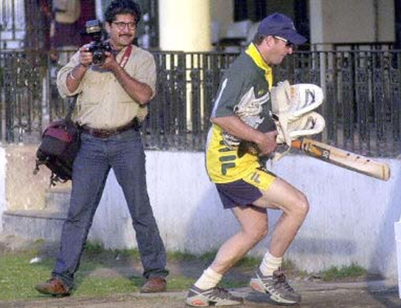 Australian star batsman Mark Waugh (R) runs away from photographers after a net practice session by the Australian team at Ferozshah Kotla ground in New Delhi, 04 March 2001. Australia will be playing India's Board President's XI team from 06 March 2001 after having already taken a 1-0 lead in the three Test match series against India.