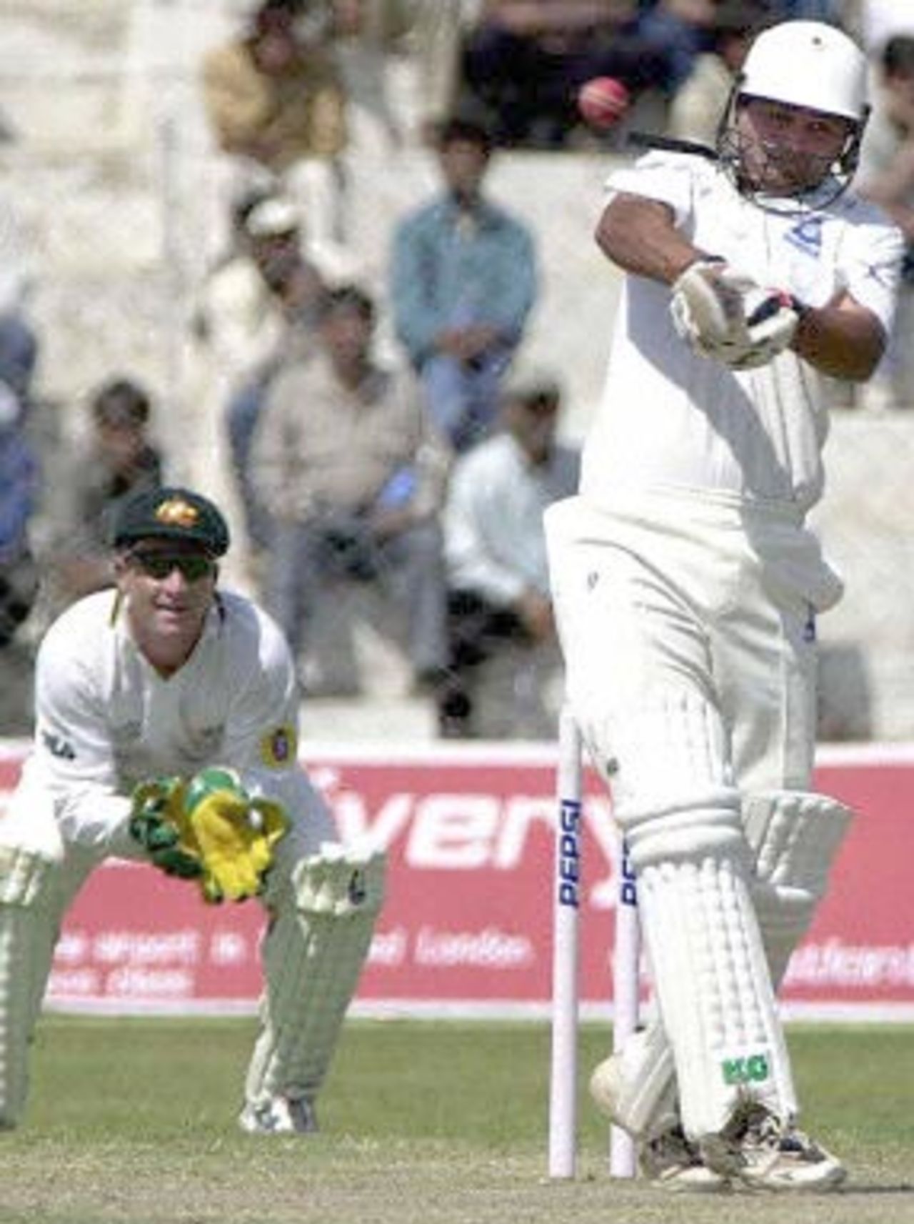 Board President's XI batsman Dinesh Mongia (R) hits a ball to the boundary as Australian wicketkeeper Brad Haddin (L) looks on during the second day of their three-day match in New Delhi 07 March 2001. Australia scored 451 in their first innings.