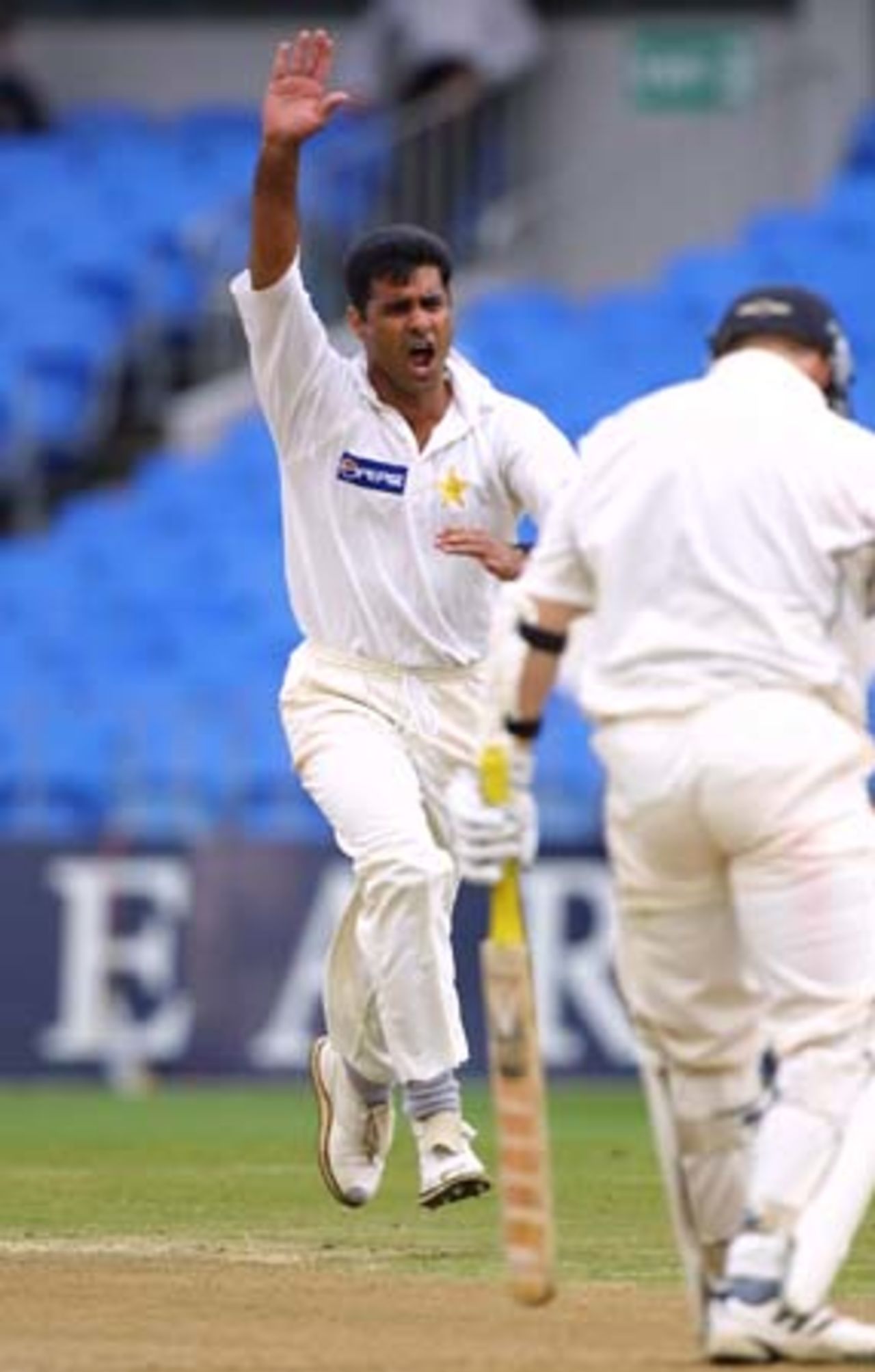 Pakistan fast medium bowler Waqar Younis runs down the wicket in celebration of dismissing New Zealand opening batsman Matthew Bell caught behind by wicket-keeper Moin Khan for a golden duck. 1st Test: New Zealand v Pakistan at Eden Park, Auckland, 8-12 March 2001 (9 March 2001).