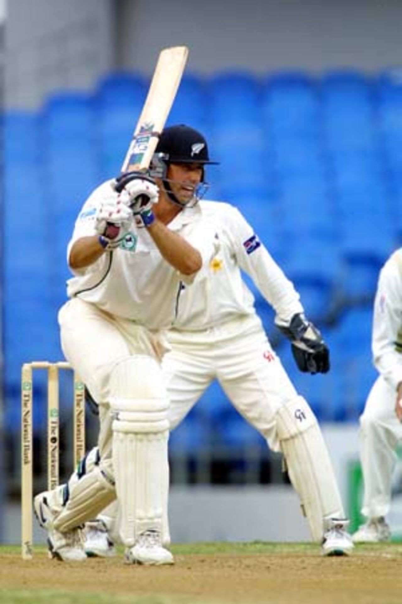 New Zealand batsman Stephen Fleming drives a ball from Pakistan off spinner Saqlain Mushtaq into the covers while wicket-keeper Moin Khan (obscured) looks on. Fleming ended the second day's play on 32 not out. 1st Test: New Zealand v Pakistan at Eden Park, Auckland, 8-12 March 2001 (9 March 2001).