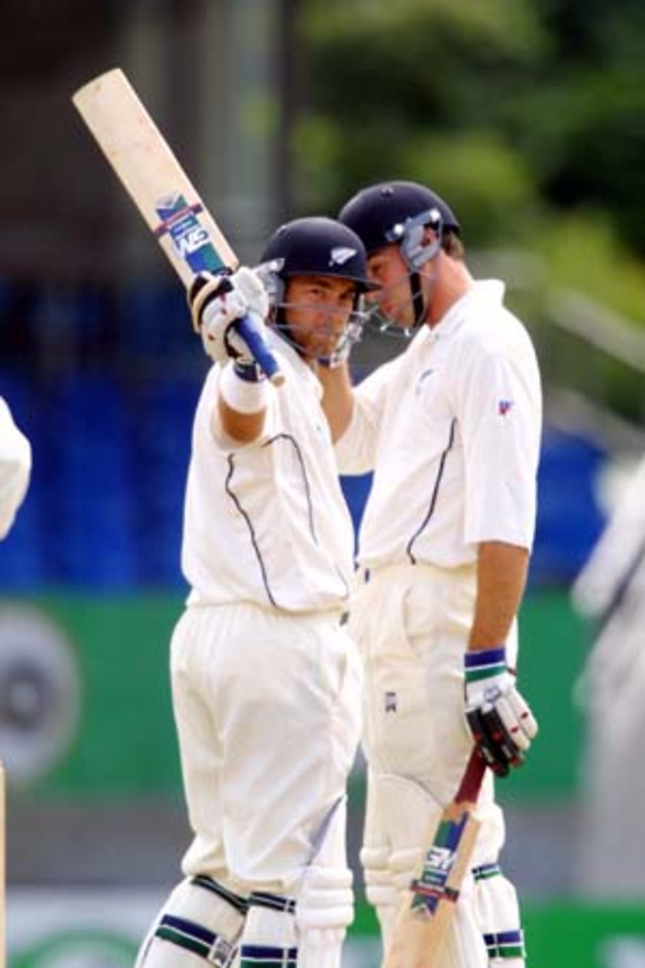 New Zealand batsman Craig McMillan raises his bat in celebration of reaching 50, during a partnership of 111 for the fifth wicket in New Zealand's first innings with Stephen Fleming (right). McMillan went on to score 54. 1st Test: New Zealand v Pakistan at Eden Park, Auckland, 8-12 March 2001 (10 March 2001).
